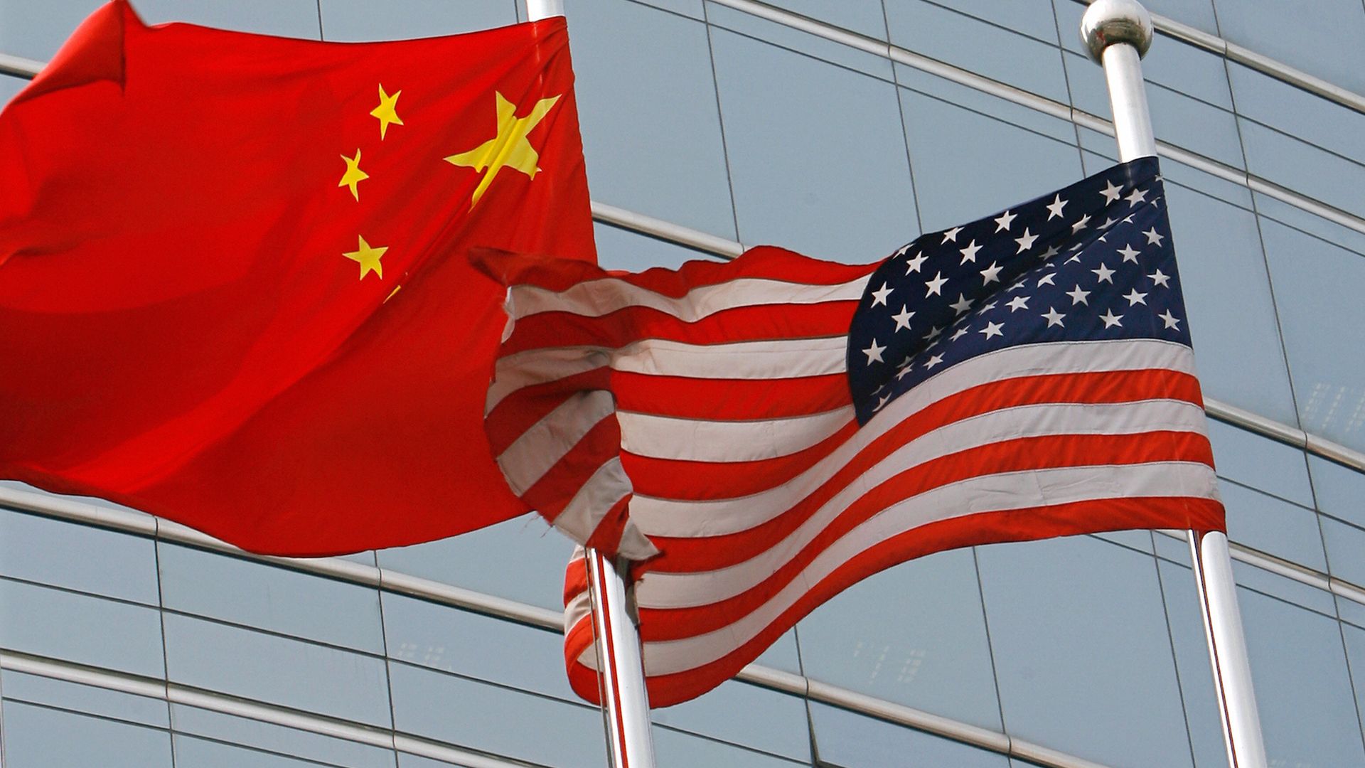 A US and a Chinese flag wave outside a commercial building in Beijing, 09 July