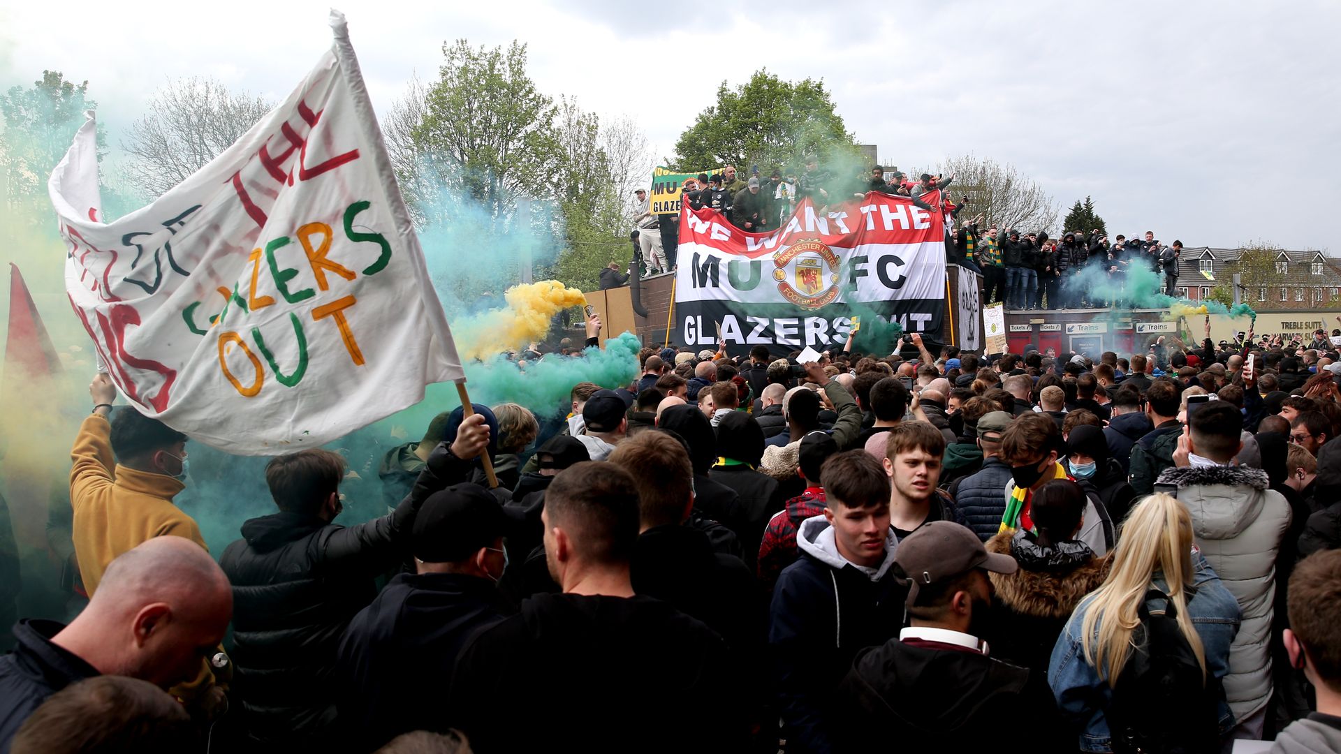 A crowd of people hold signs