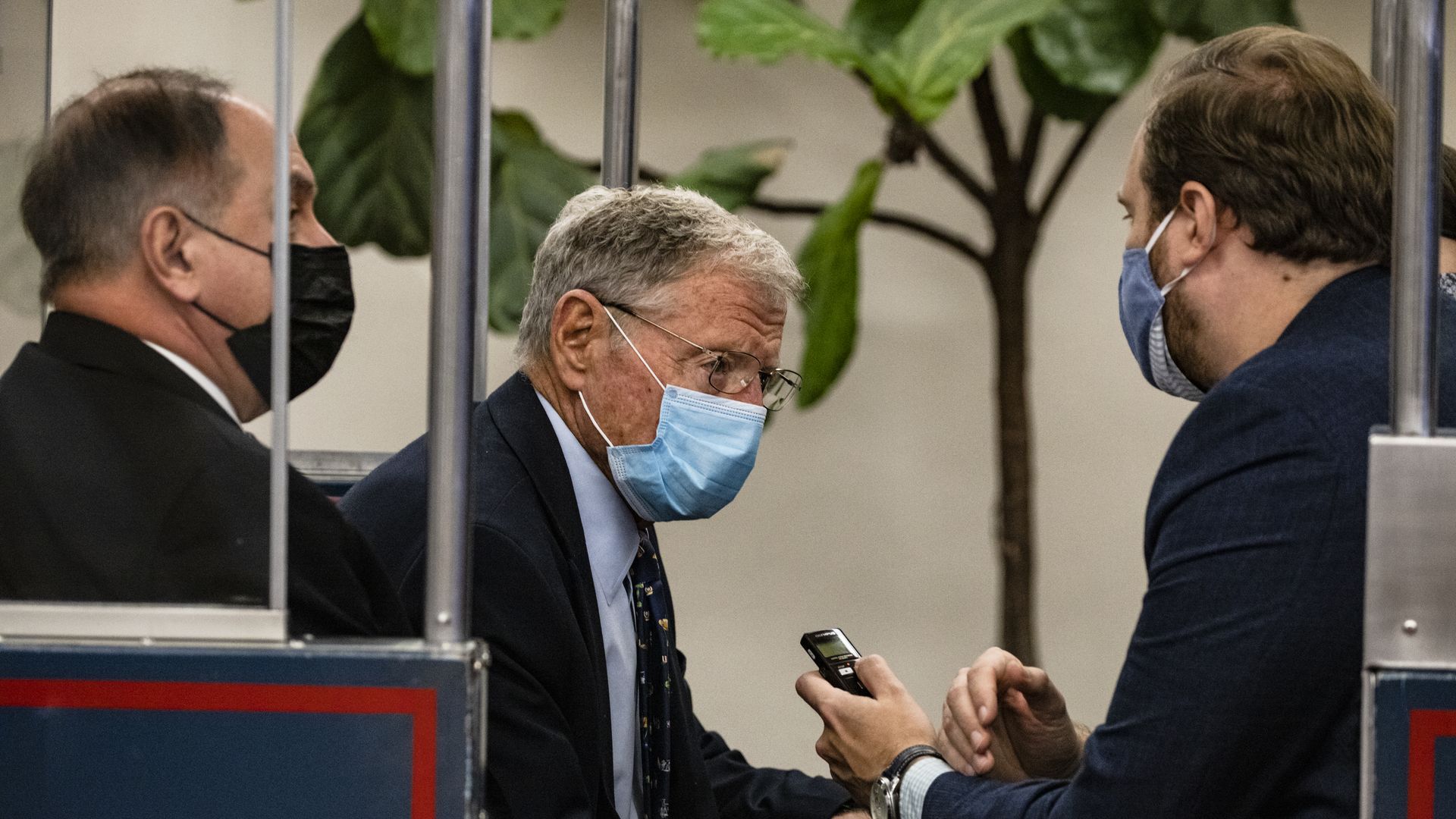 Senator Jim Inhofe sits in a Capitol subway car while speaking with reporters.