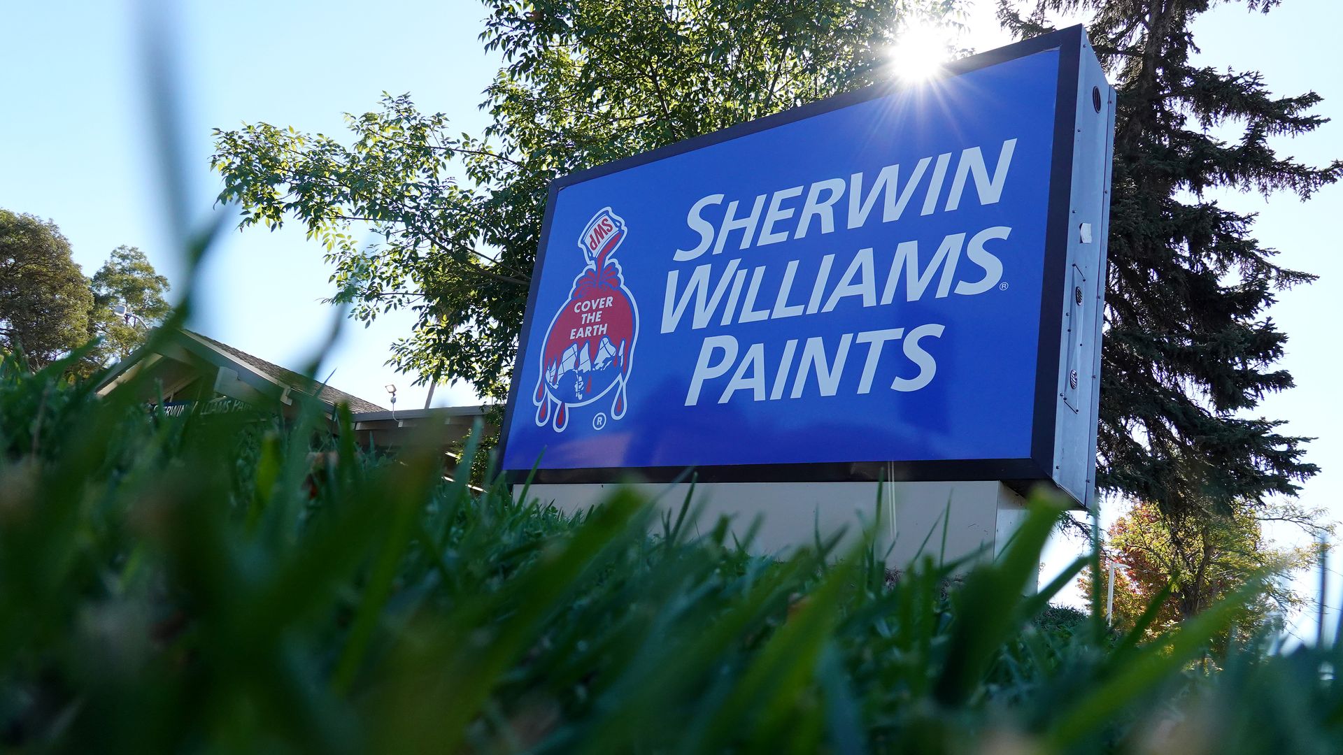 Blue sign reading Sherwin Williams Paints. Photo from the grass.