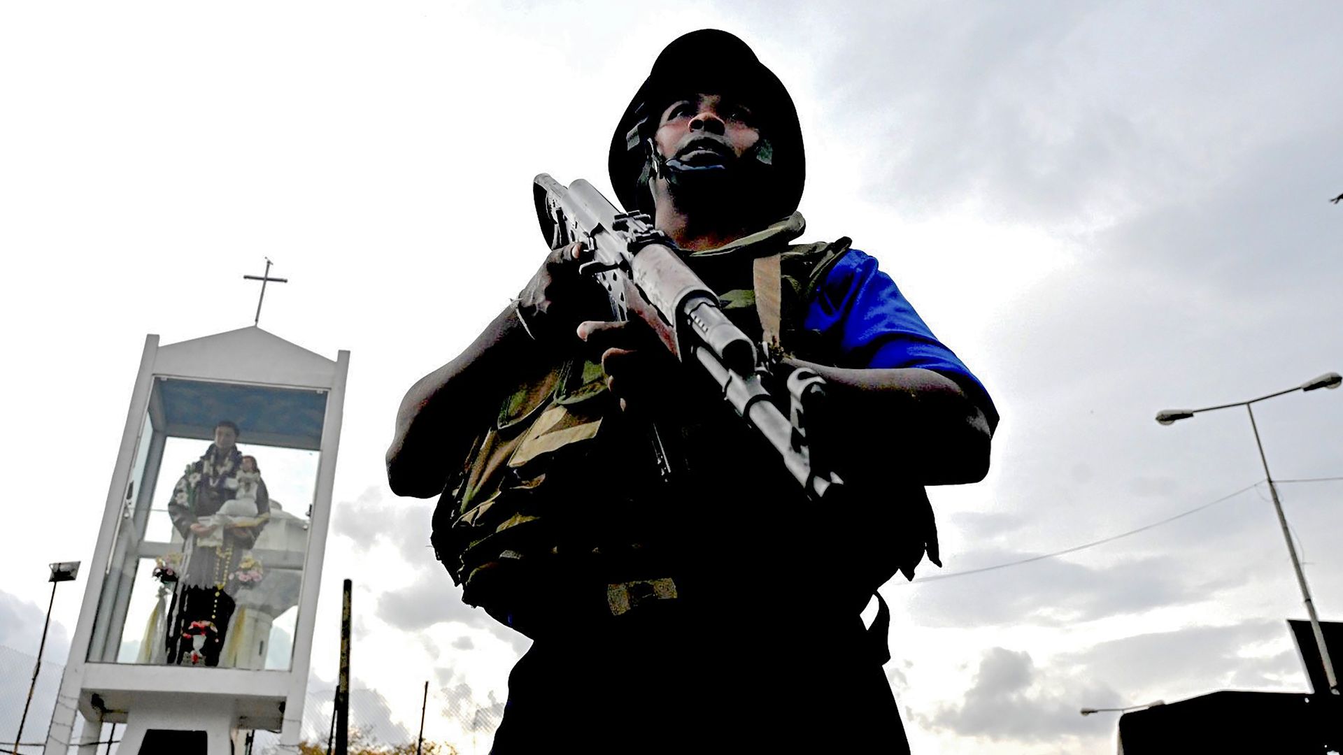 A Sri Lankan soldier stands guard near a car explosion after the police tried to defuse a bomb near St. Anthony's Shrine in Colombo on Monday.