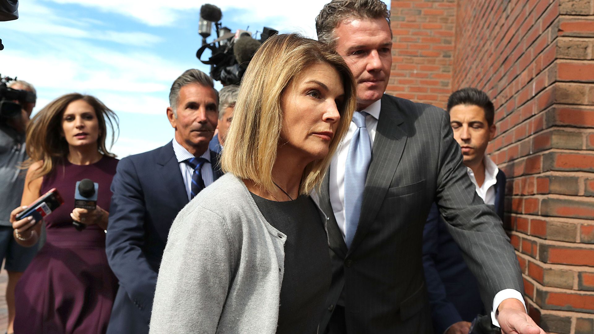 Loughlin and her husband Mossimo Giannulli, behind her at left, leave the John Joseph Moakley United States Courthouse in Boston on Aug. 27, 2019. 