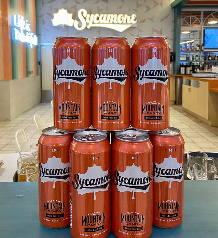 Sycamore Brewing's Mountain Candy in front of an illuminated Sycamore sign. Photo: Ashley Mahoney/Axios 