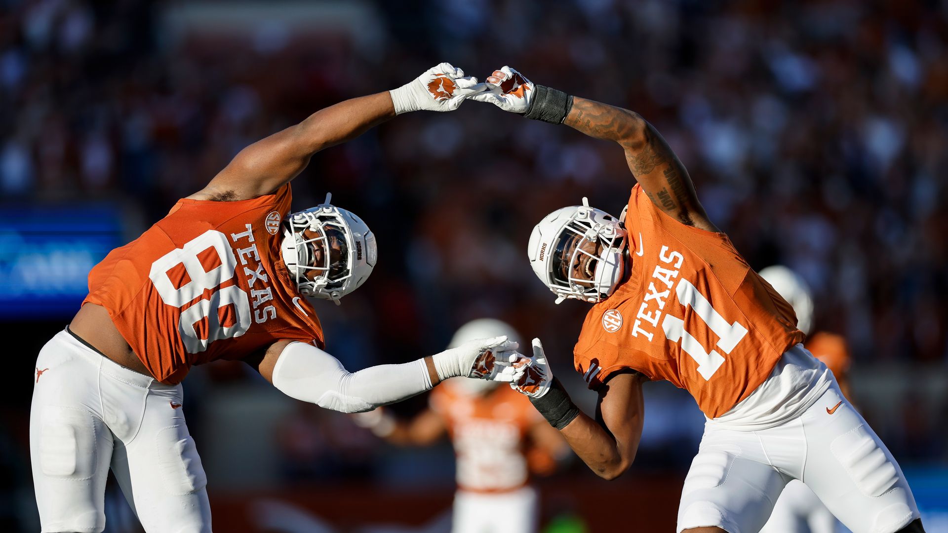 Texas football players celebrating while joining hands.