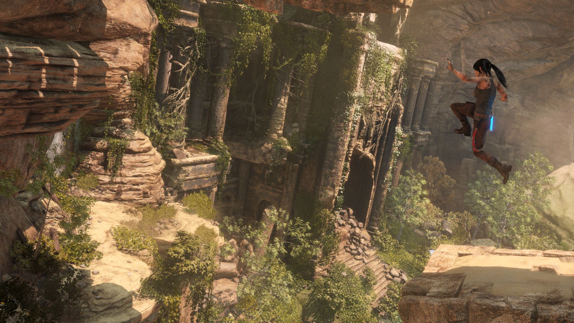 Video game screenshot of a woman leaping across a chasm toward an ancient temple