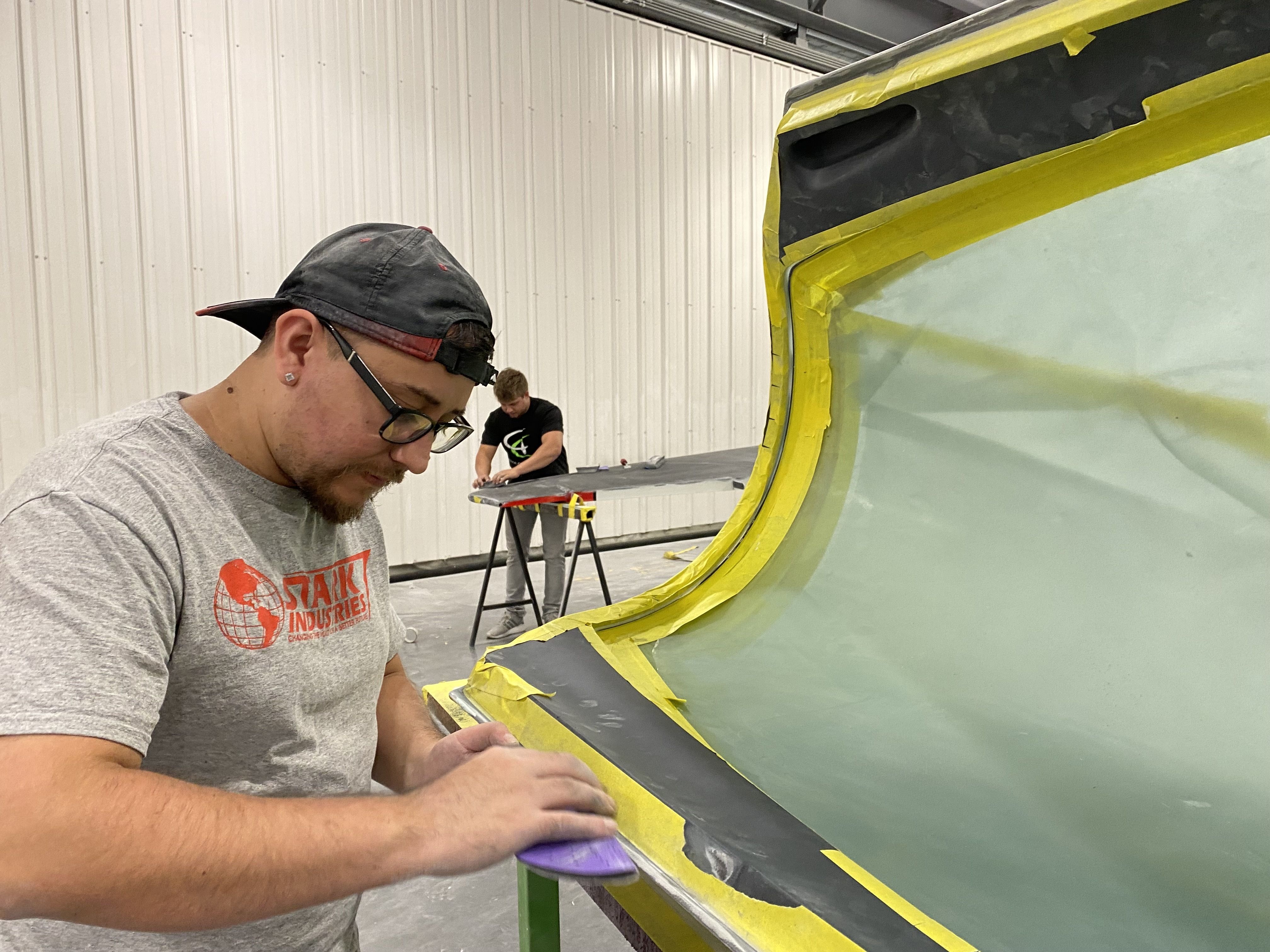 A worker preps part of a plane for painting. 