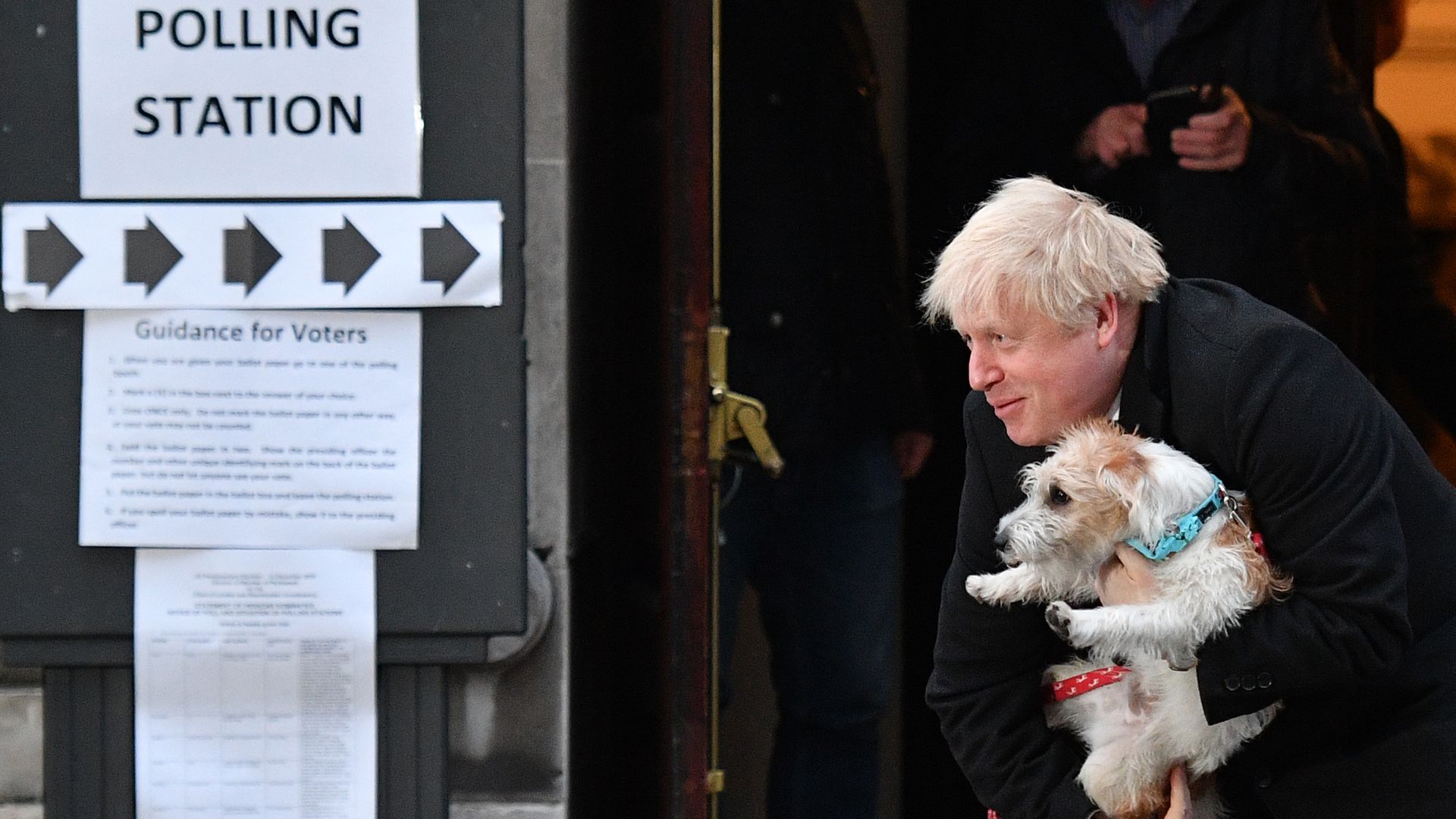 Britain's Prime Minister Boris Johnson poses with his dog Dilyn as he leaves from a Polling Station