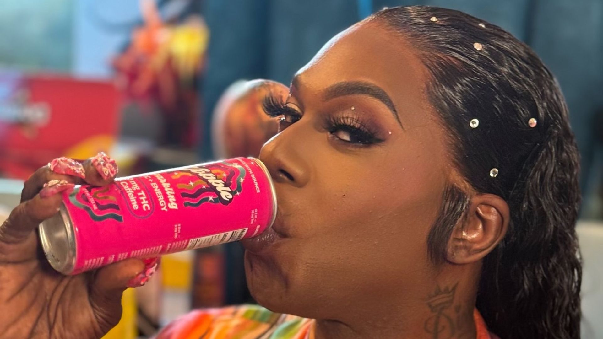 Big Freedia drinks out of a hot pink can.