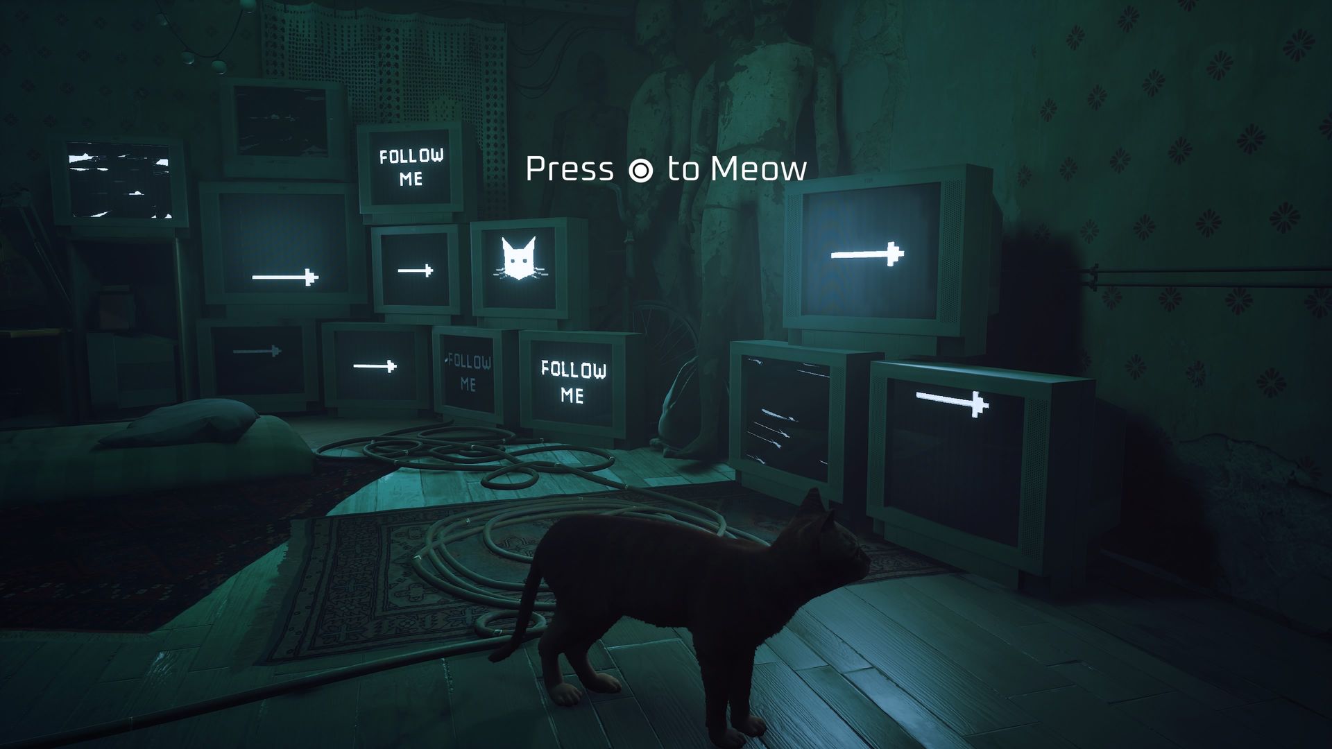 Video game screenshot of a cat in a room filled with TVs. A prompt on screen states "Press circle button to meow"