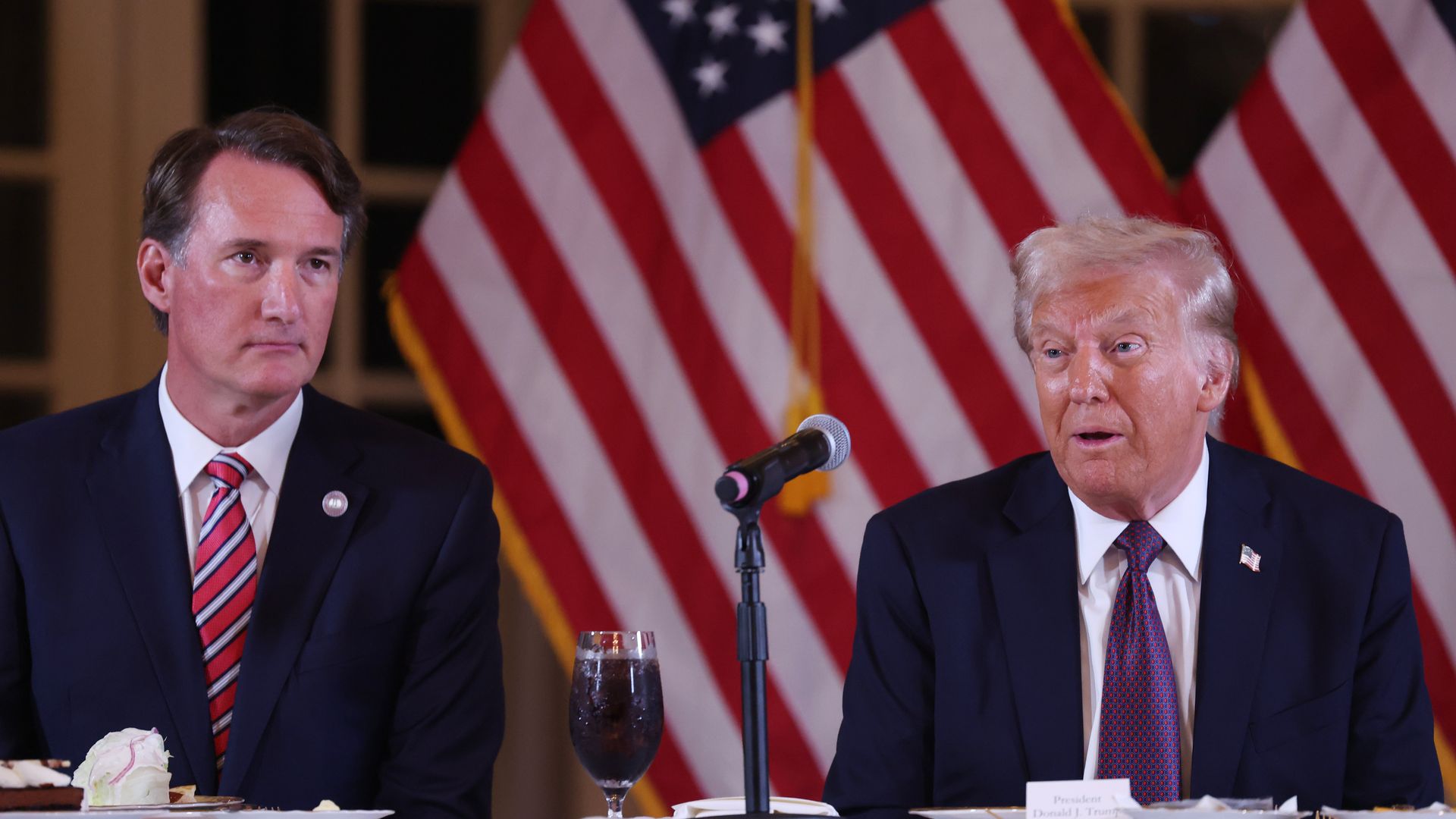 Gov. Glenn Youngkin sat next to Trump with American flags behind them