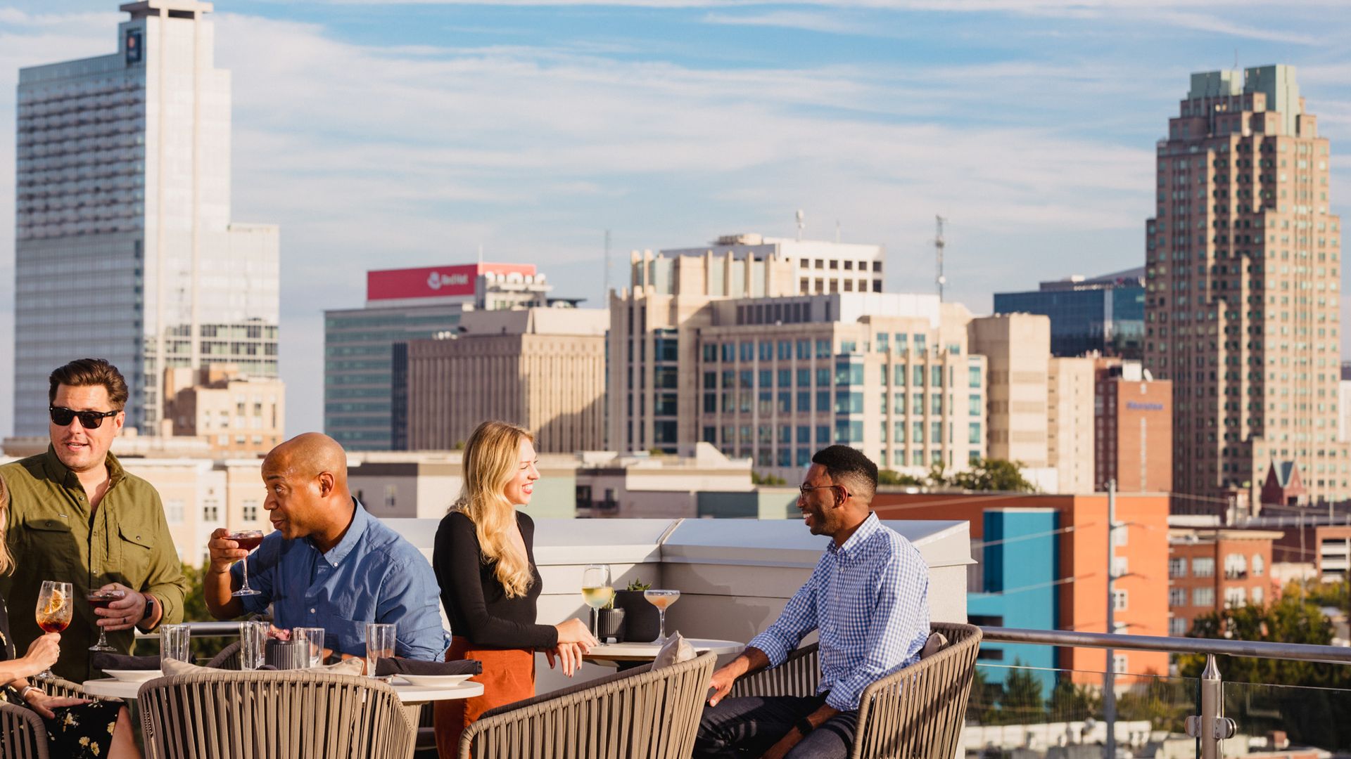 People dine in front of the Raleigh skyline