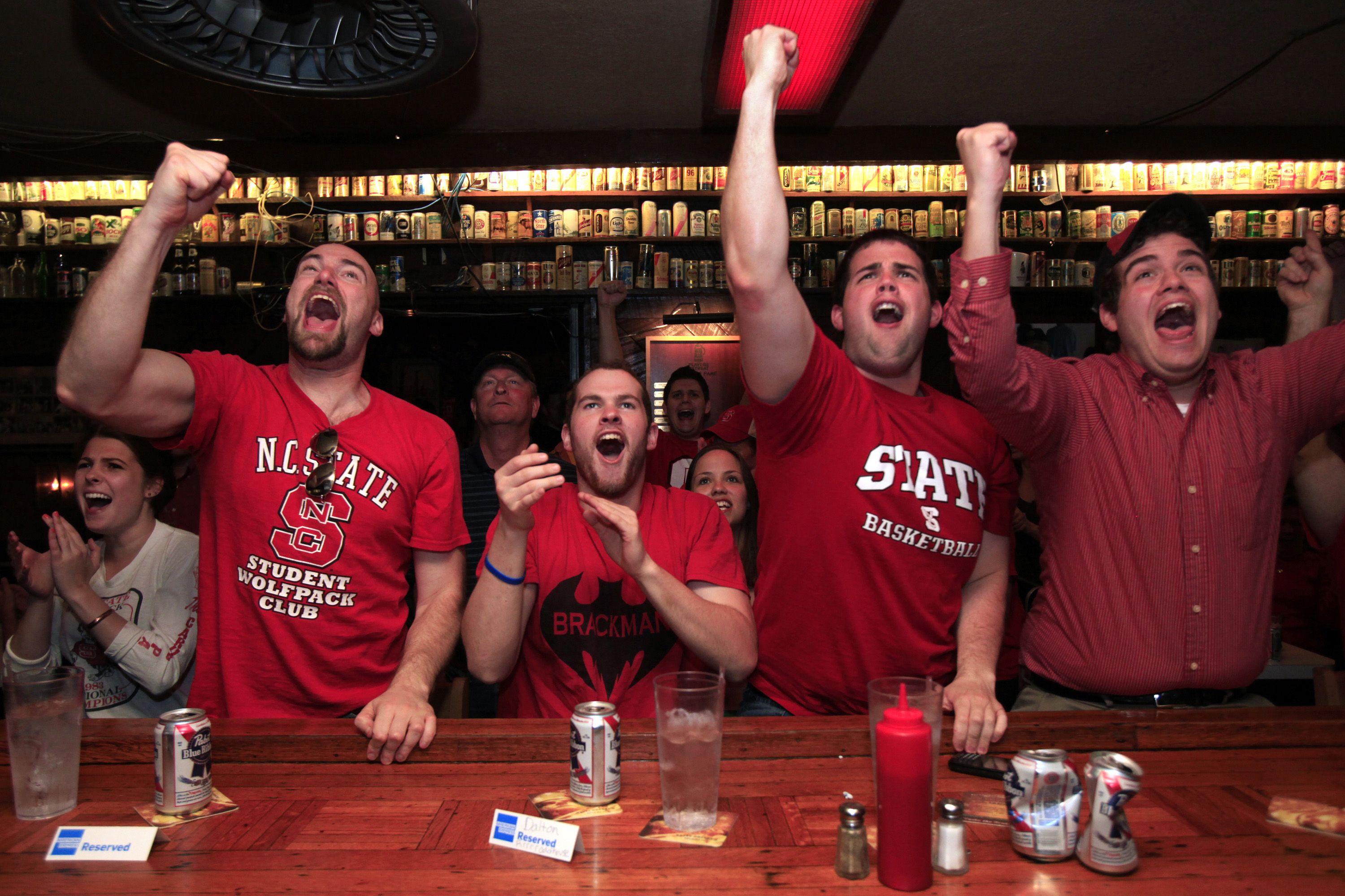 At The Players' Retreat, a sports bar in Raleigh, North Carolina, North Carolina State fans, from left, Joe Zaborowski, Brian Schilling, Joe Kasperski and Matt Kasperski, celebrate the Wolfpack's 66-63 victory over Georgetown in the third round of the NCAA Tournament, Sunday, March 18, 2012. (Takaaki Iwabu/Raleigh News & Observer/Tribune News Service via Getty Images)