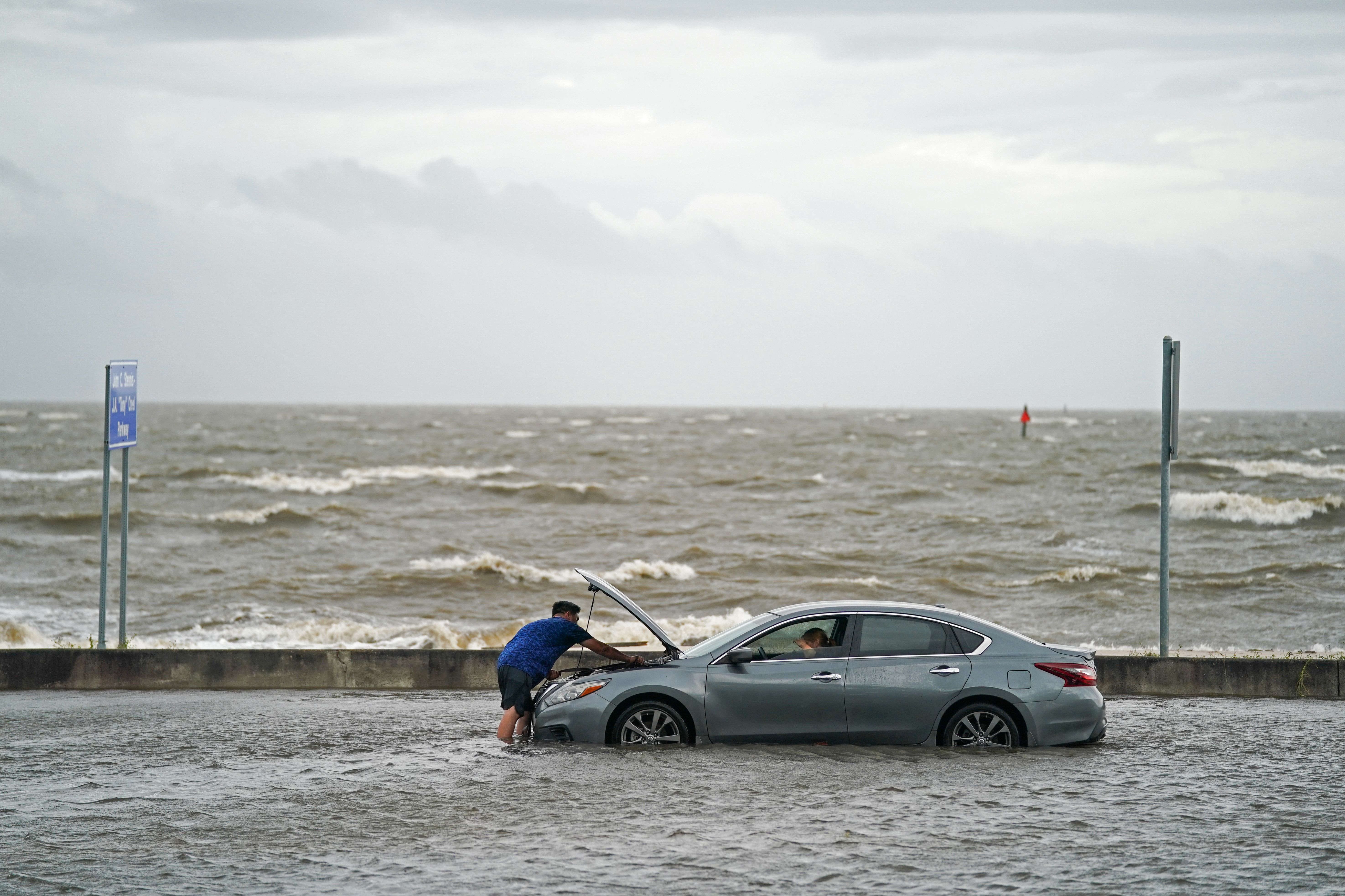 A man helps a stranded motorist in floodwaters on Beach Blvd. on August 30, 2021 in Biloxi, Mississippi. 