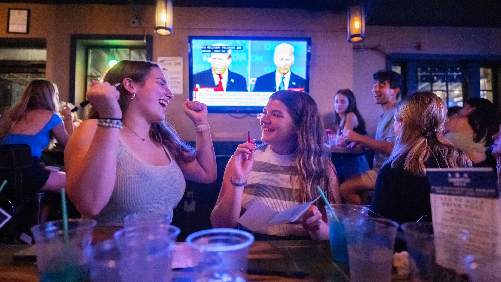 Megan Talbott and Abigail Hageman react while playing with their custom made bingo cards as they watch the first Presidential debate of the 2024 election between former President Donald Trump and President Joe Biden at Union Pub in Washington, DC on June 27, 2024. (Photo by Craig Hudson for The Wash
