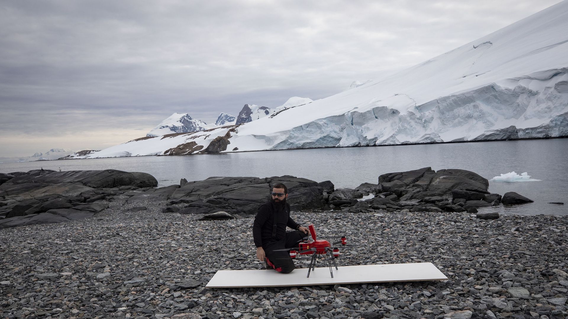 scientist with a lidar-equipped drone on rocky Antarctic shore