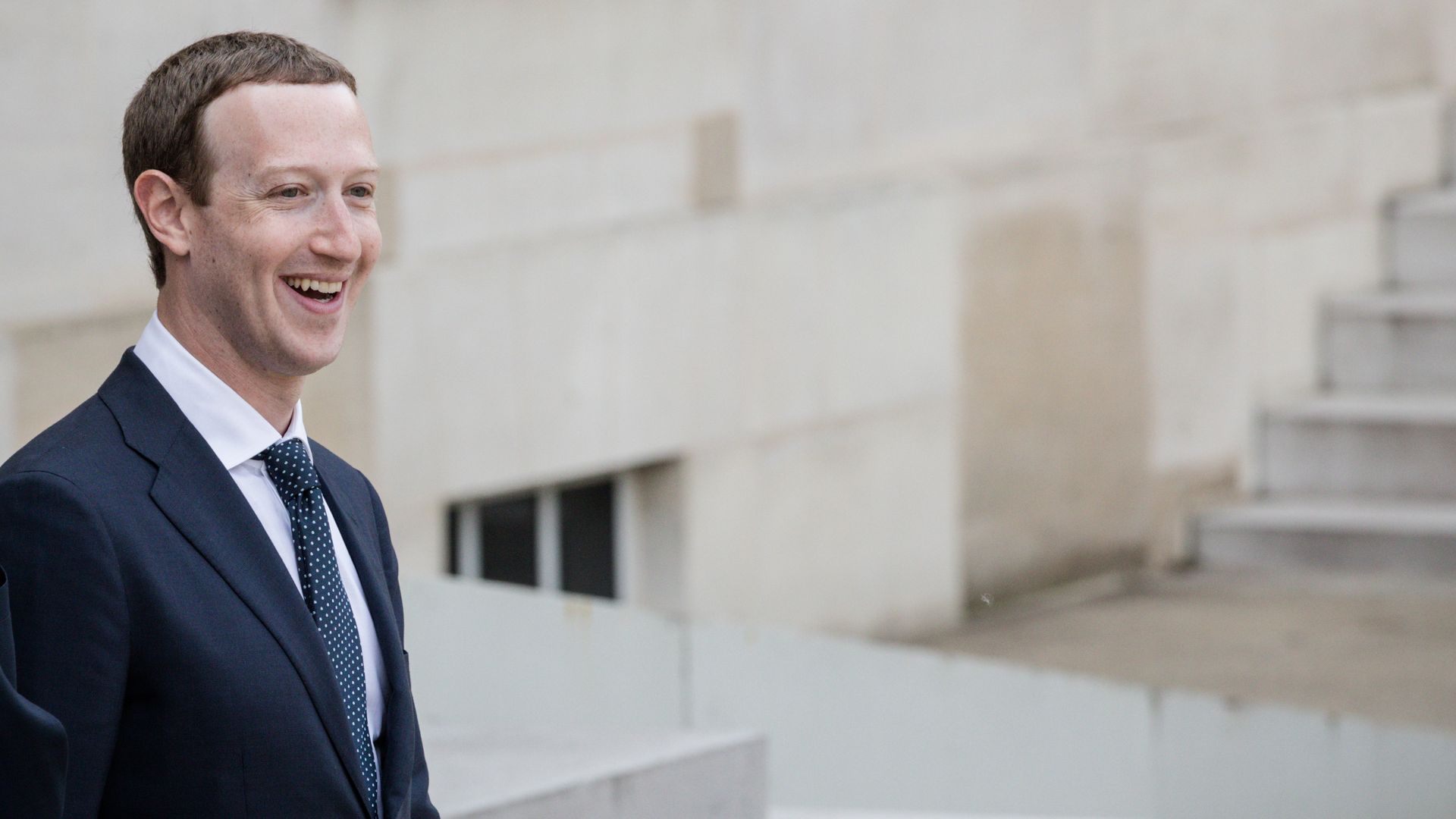 A man smiles wearing a suit