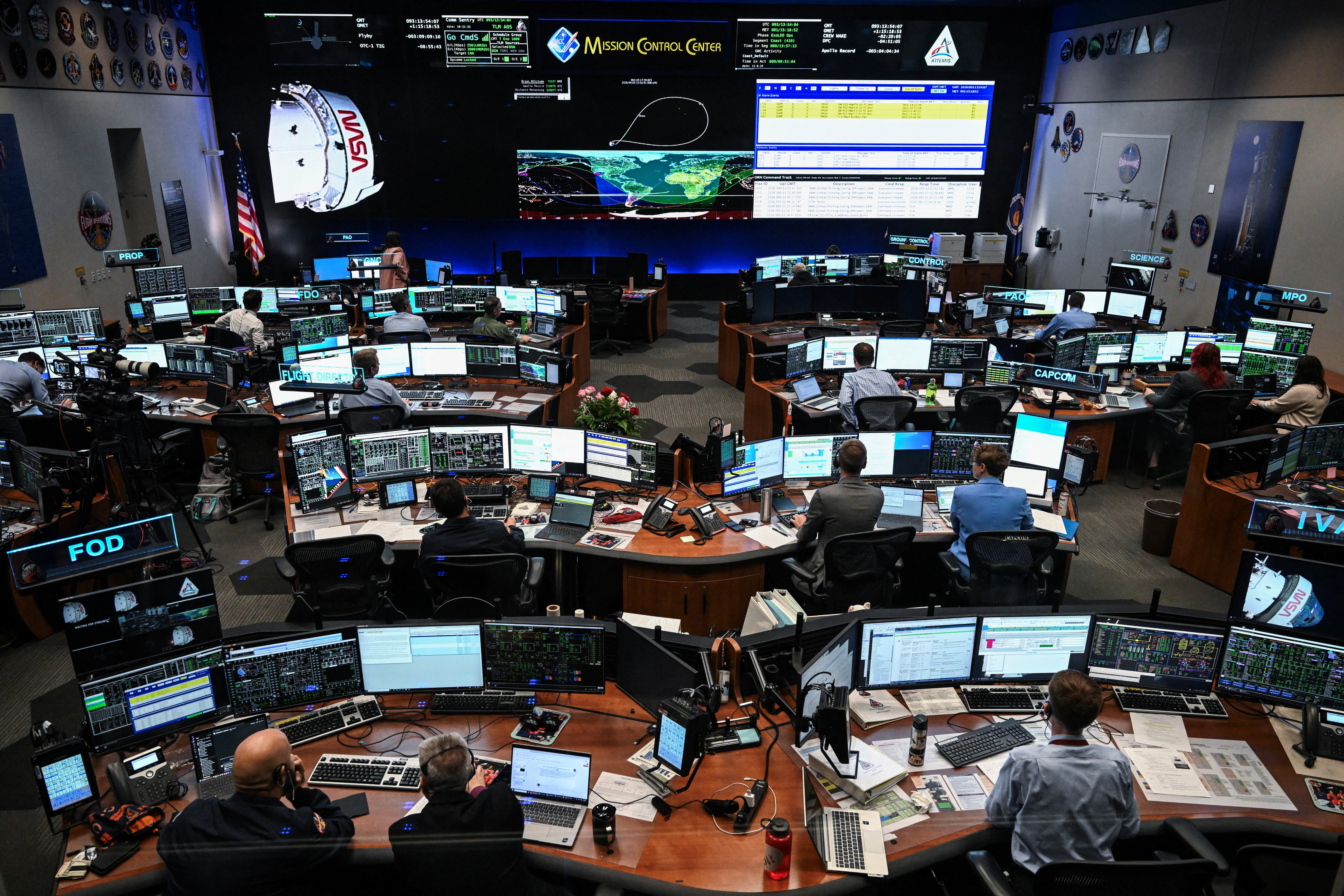 Artemis II controllers monitor the progress of the Orion spacecraft in the White Flight Control Room at Johnson Space Center in Houston, Texas, on April 3, 2026. Four Artemis astronauts were zooming towards the Moon late April 2 after a major engine firing, a milestone that commits NASA to the first