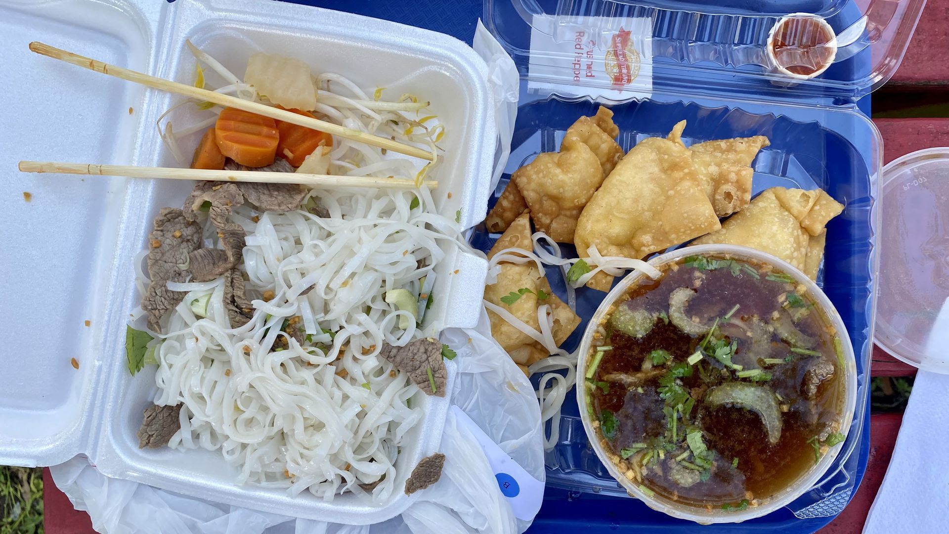 Photo of to-go orders of beef noodle soup and crab rangoon at the Thai Temple.