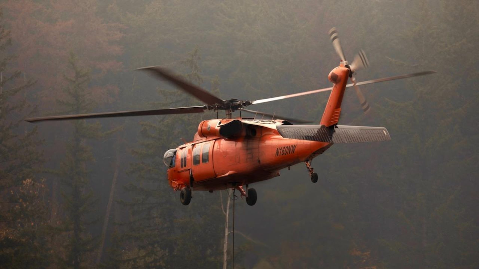 A helicopter drops water on a 2022 fire in King County, Washington. 