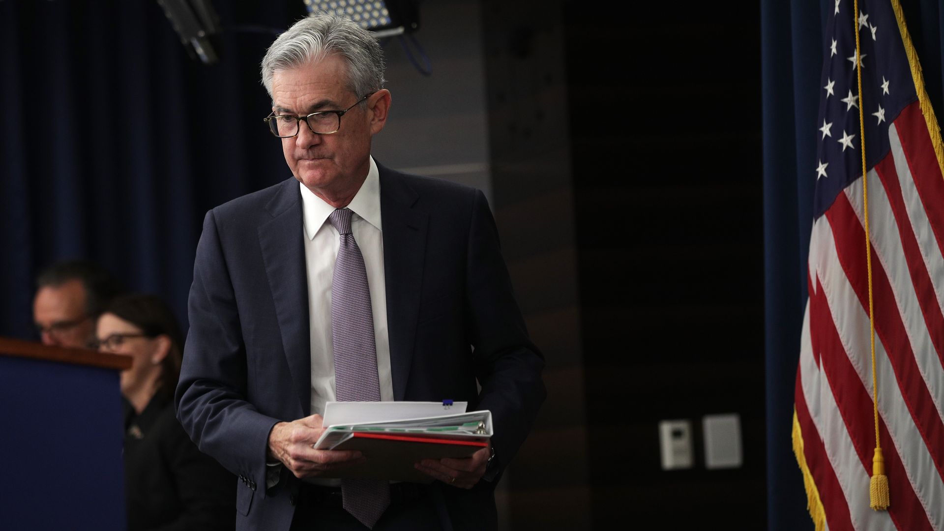Federal Reserve chair Jerome Powell carries a binder to a podium, following the Fed's rate decision in September