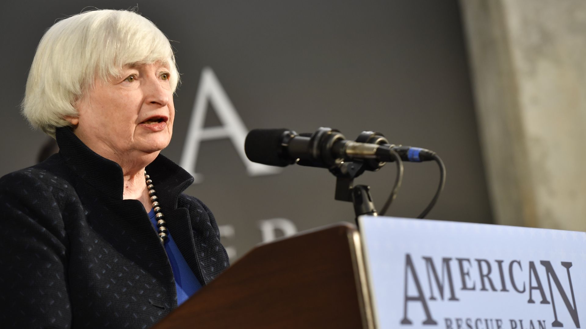 Treasury Secretary Janet Yellen speaks at a podium with the sign "American Rescue Plan"  