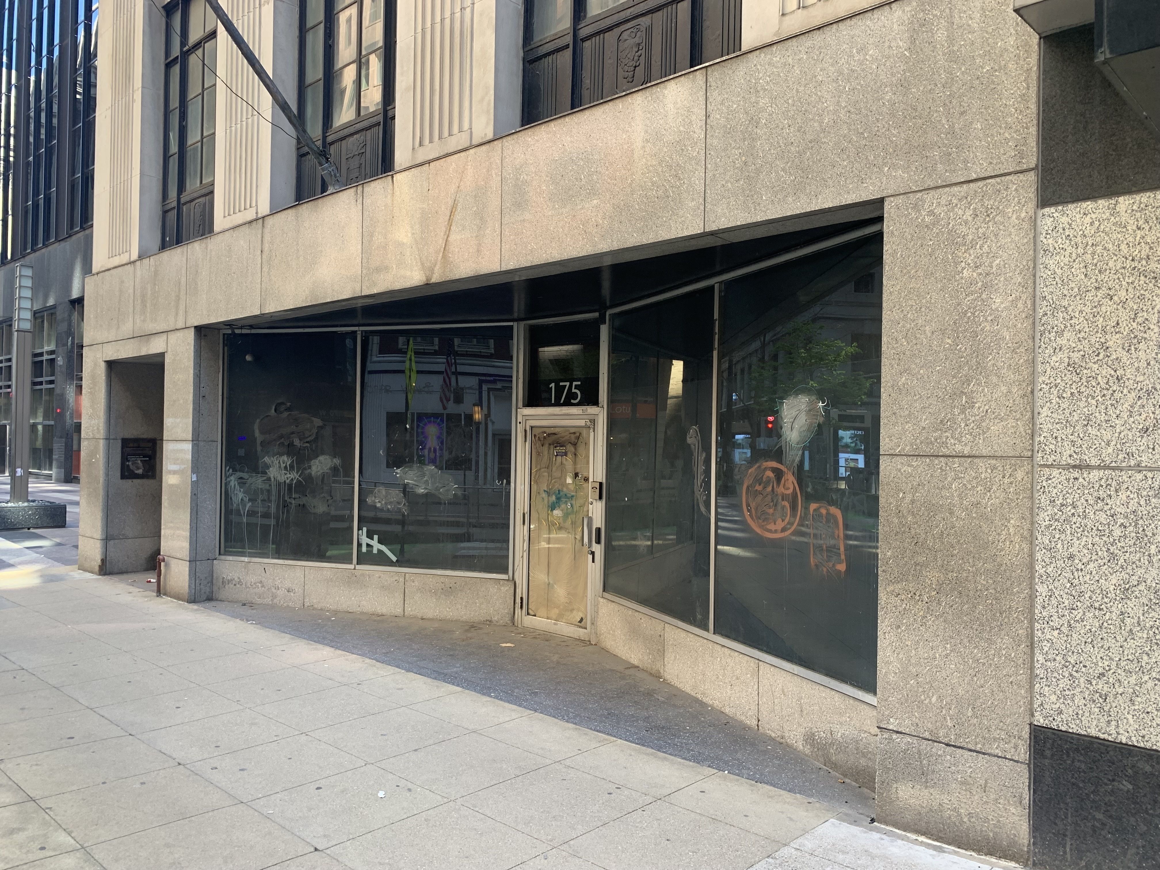 Storefront of limestone building with brown paper in the front door window.