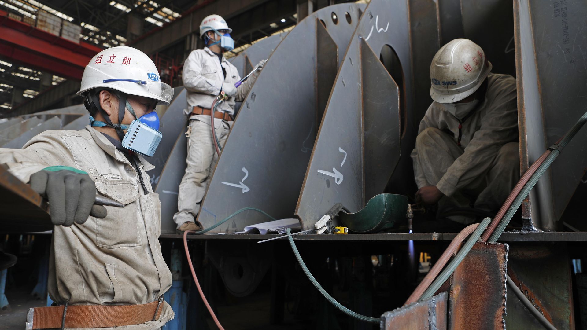 Employees wearing face masks weld parts of ship at Shanghai Waigaoqiao Shipbuilding (SWS) company amid the novel coronavirus outbreak on March 3, 2020 in Shanghai, China.