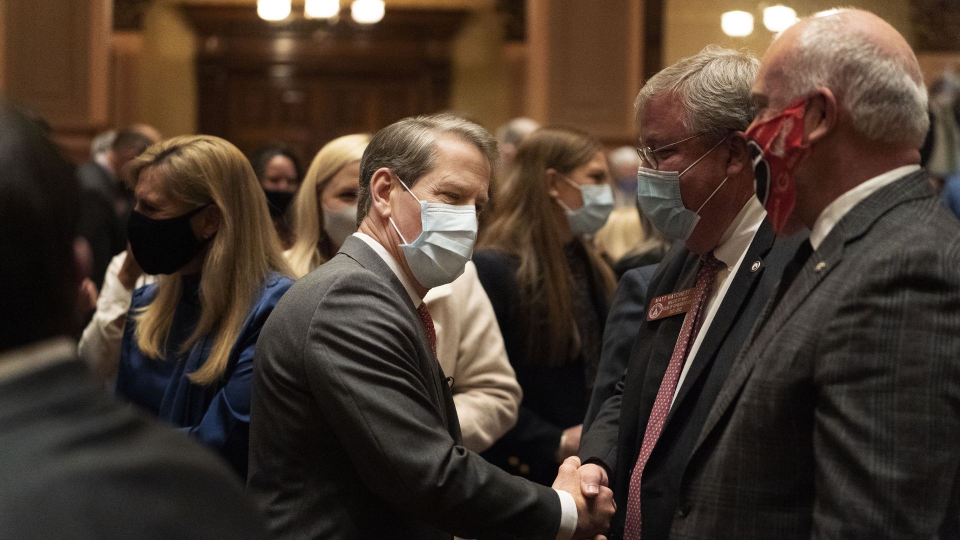 Kemp shakes hands with lawmakers wearing masks