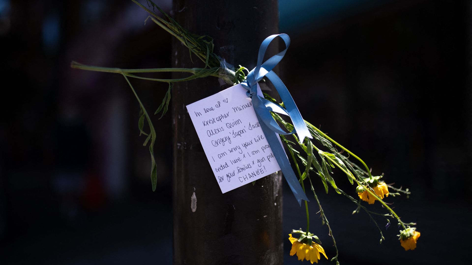 A note and flowers honoring victims of a mass shooting in South Philadelphia.