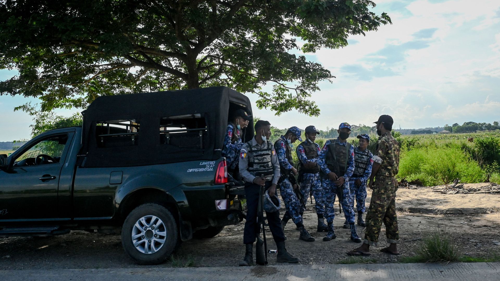Security forces stand guard as people dismantle their slum homes in the Thianlyin township of Yangon on October 28.