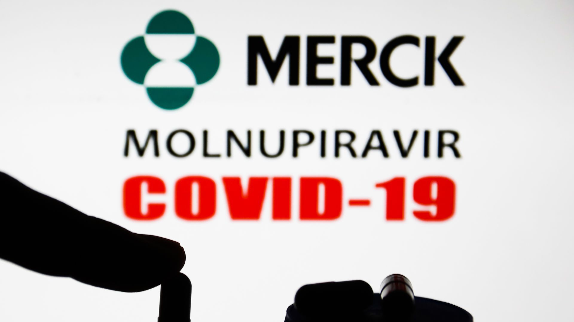 A illustration showing the Merck logo and someone holding a pill.