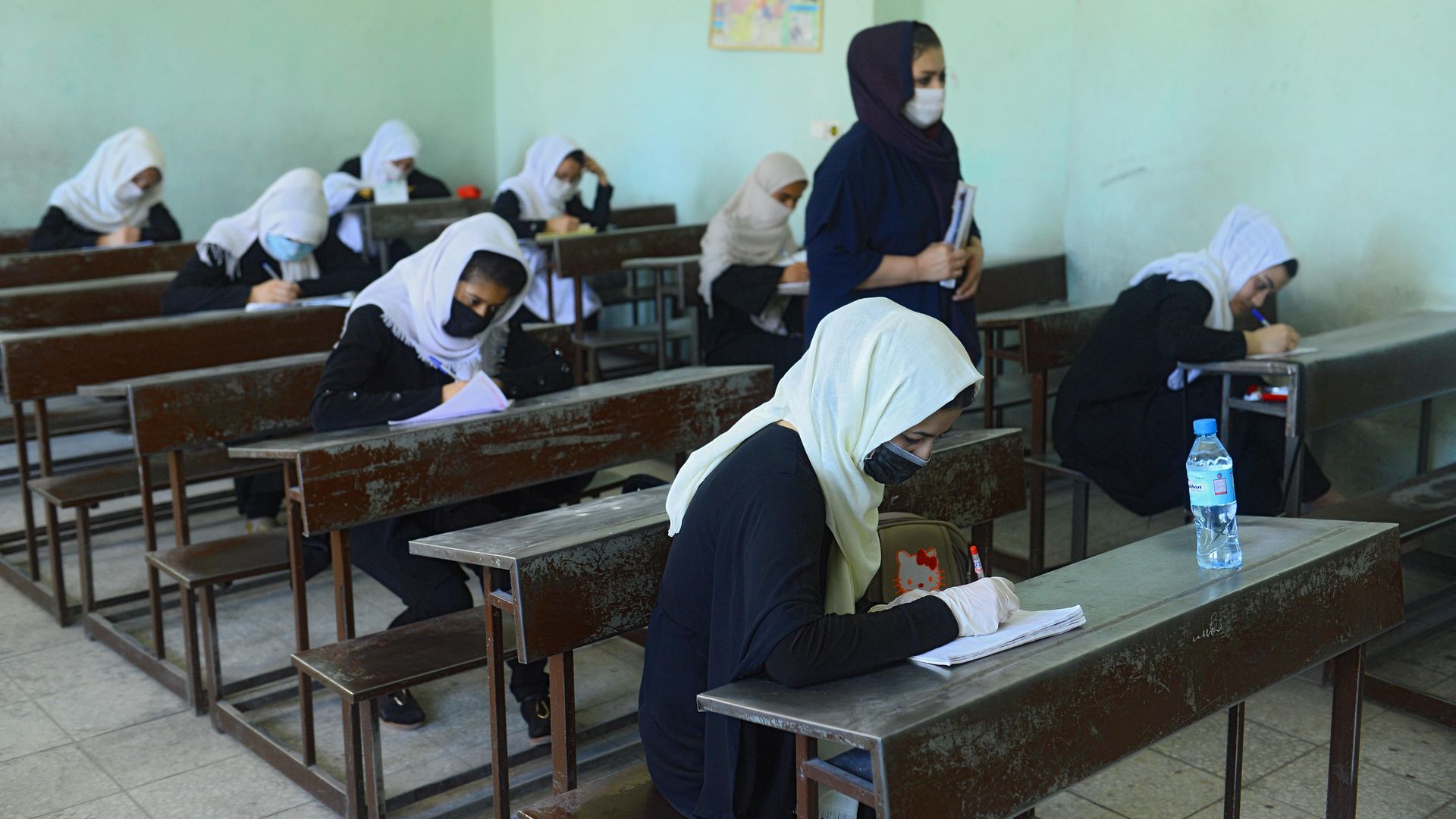 Afghan girl students wearing facemasks attend a class on the first day after their school was reopened, which was earlier closed due to the COVID-19 coronavirus pandemic, in Herat on August 22, 2020.
