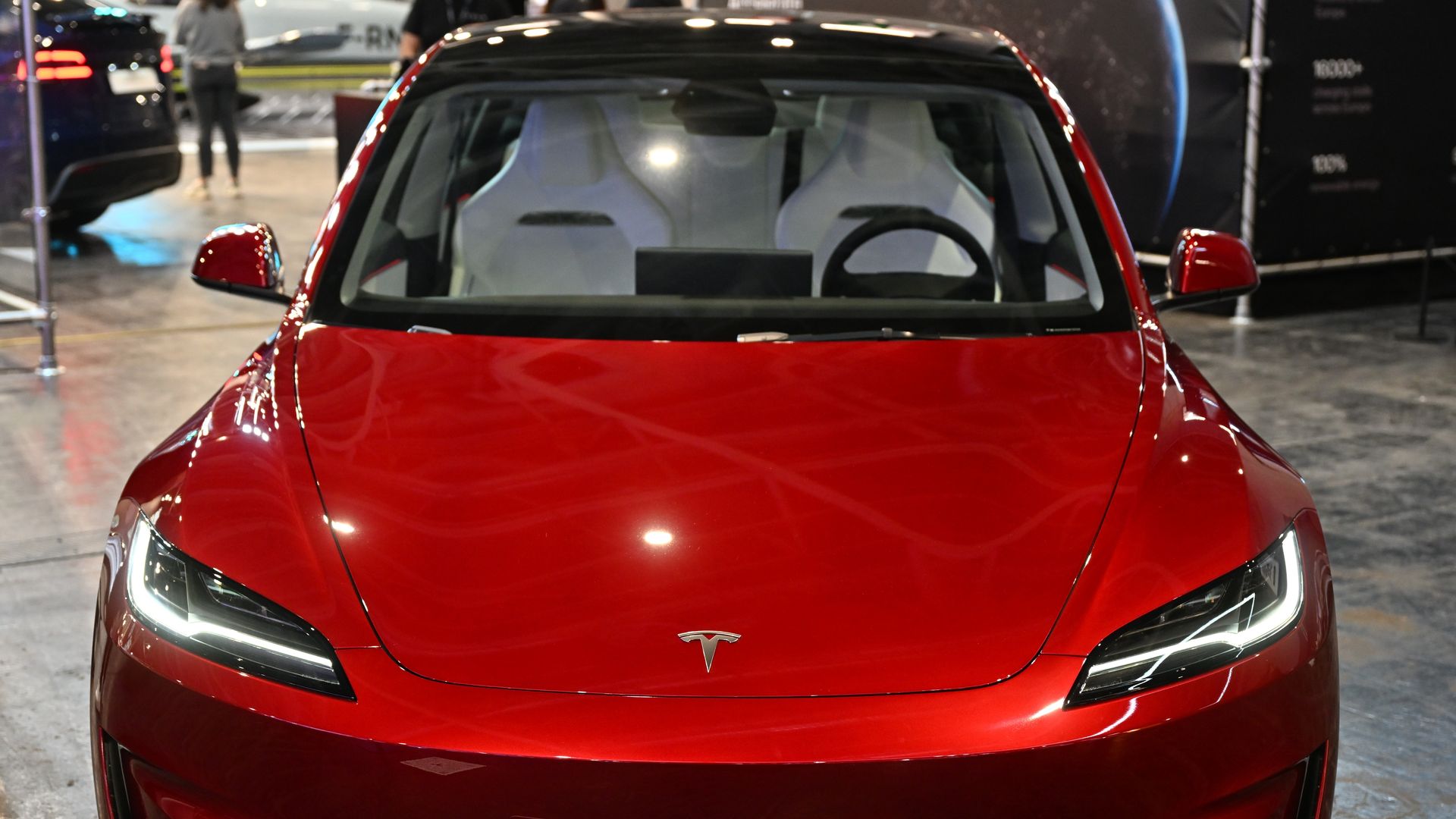 A red Tesla viewed from the front