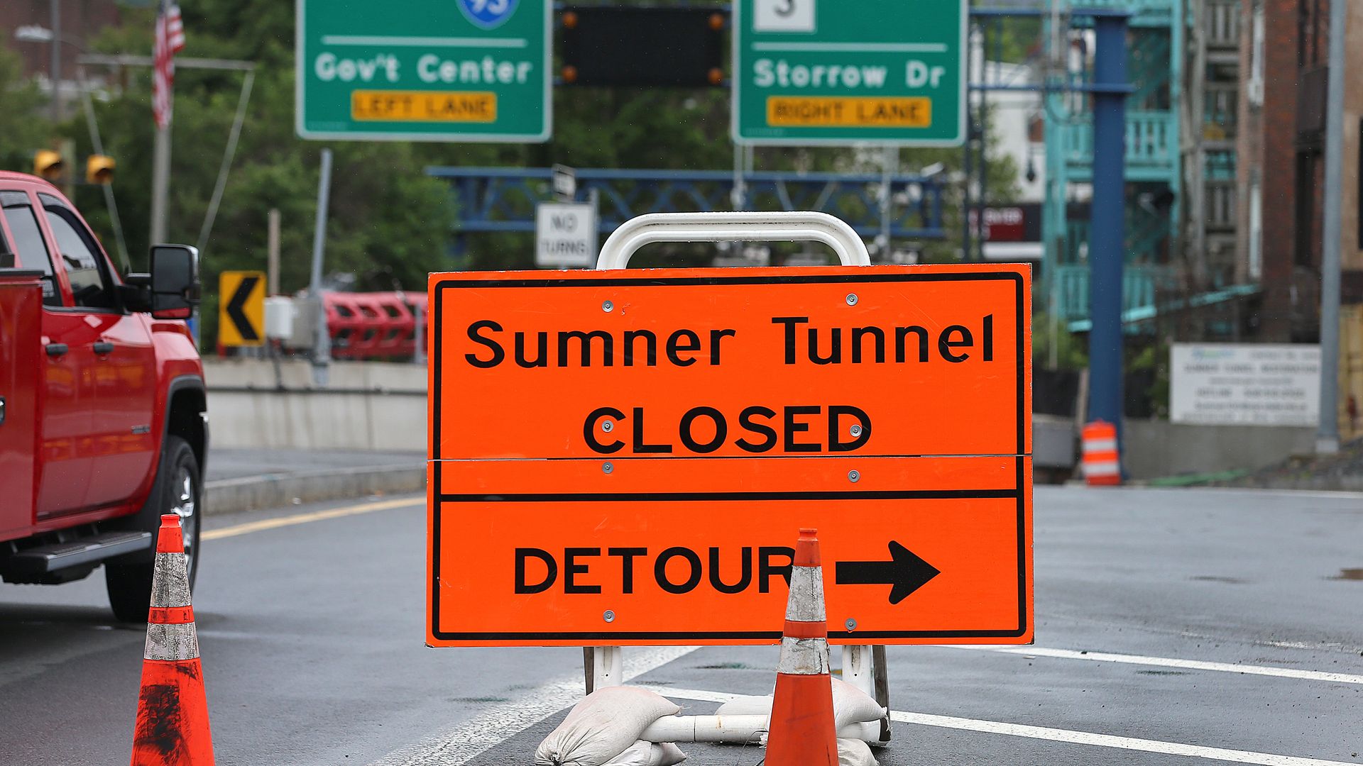An orange traffic sign that says "Sumner Tunnel CLOSED" pointing to a detour.