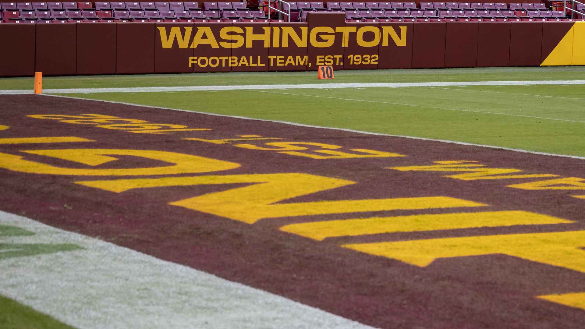 A close-up of a Washington Football Team sign on Fed-Ex field near the end zone.