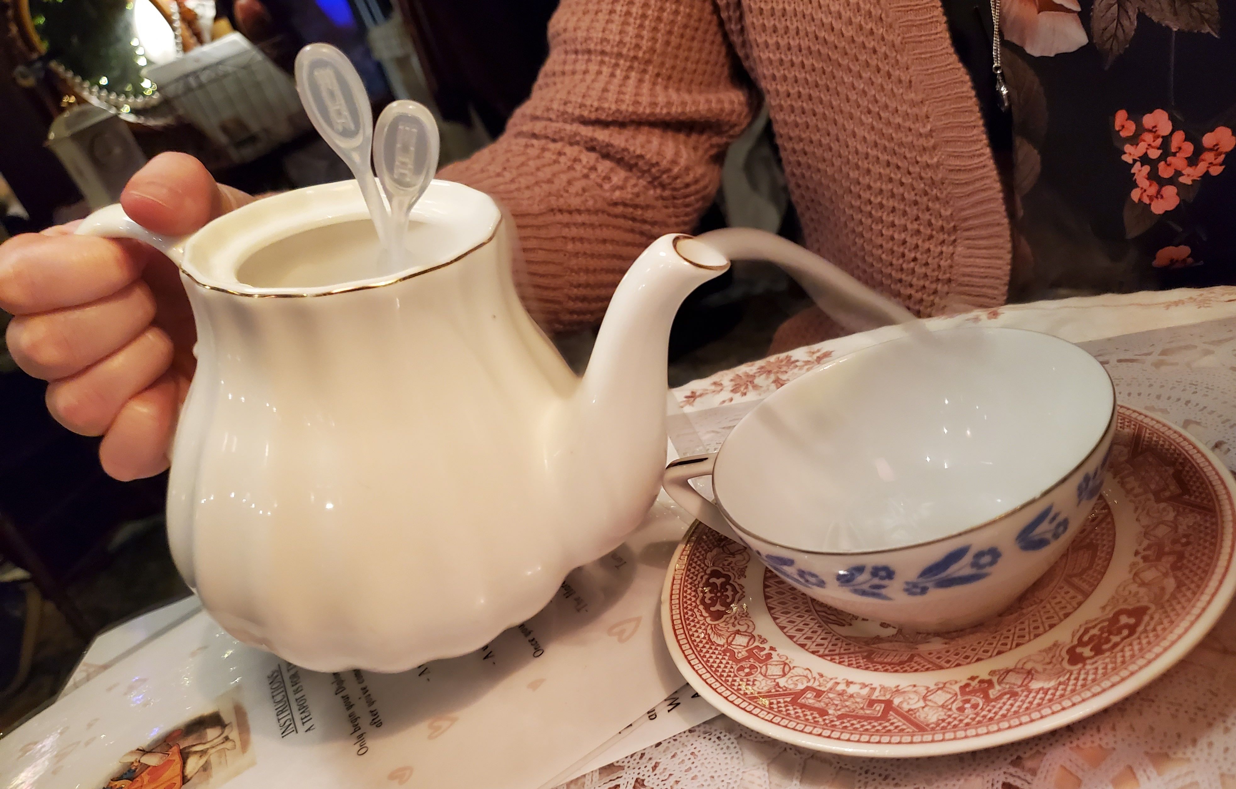 A tea pot "steams" with dry ice as its contents are poured into a tea cup