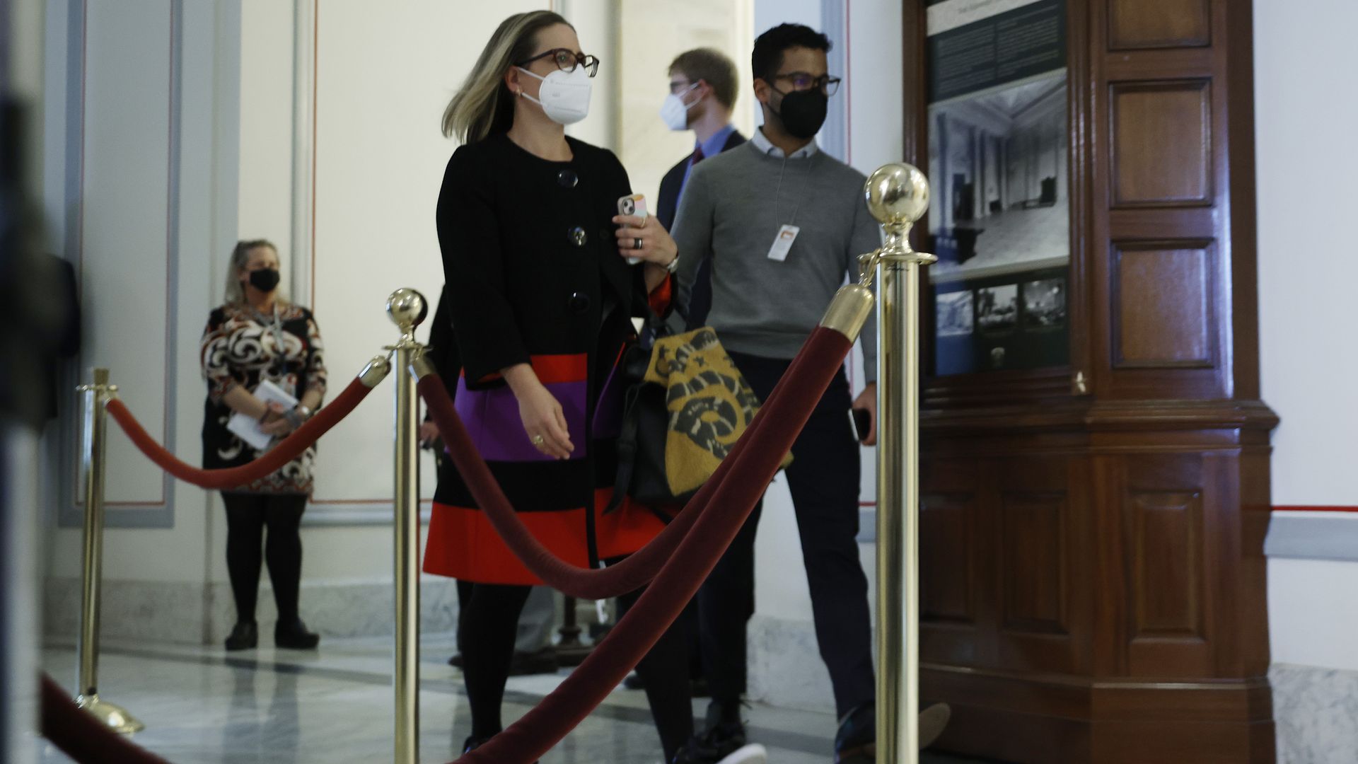 Sen. Kyrsten Sinema is seen entering a Democratic caucus meeting with President Biden.