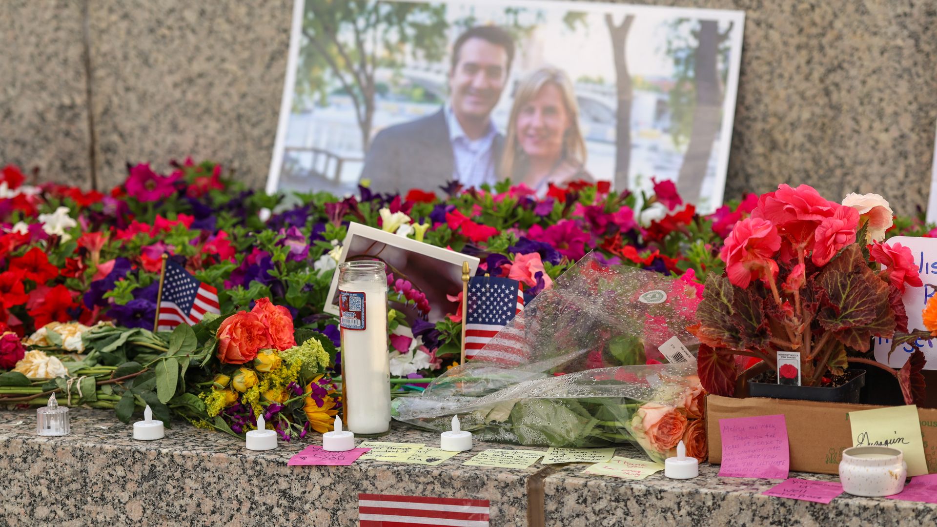 A makeshift memorial for DFL State Rep. Melissa Hortman and her husband Mark Hortman with candles, flowers and a photo of the couple was set up at the State Capitol building.