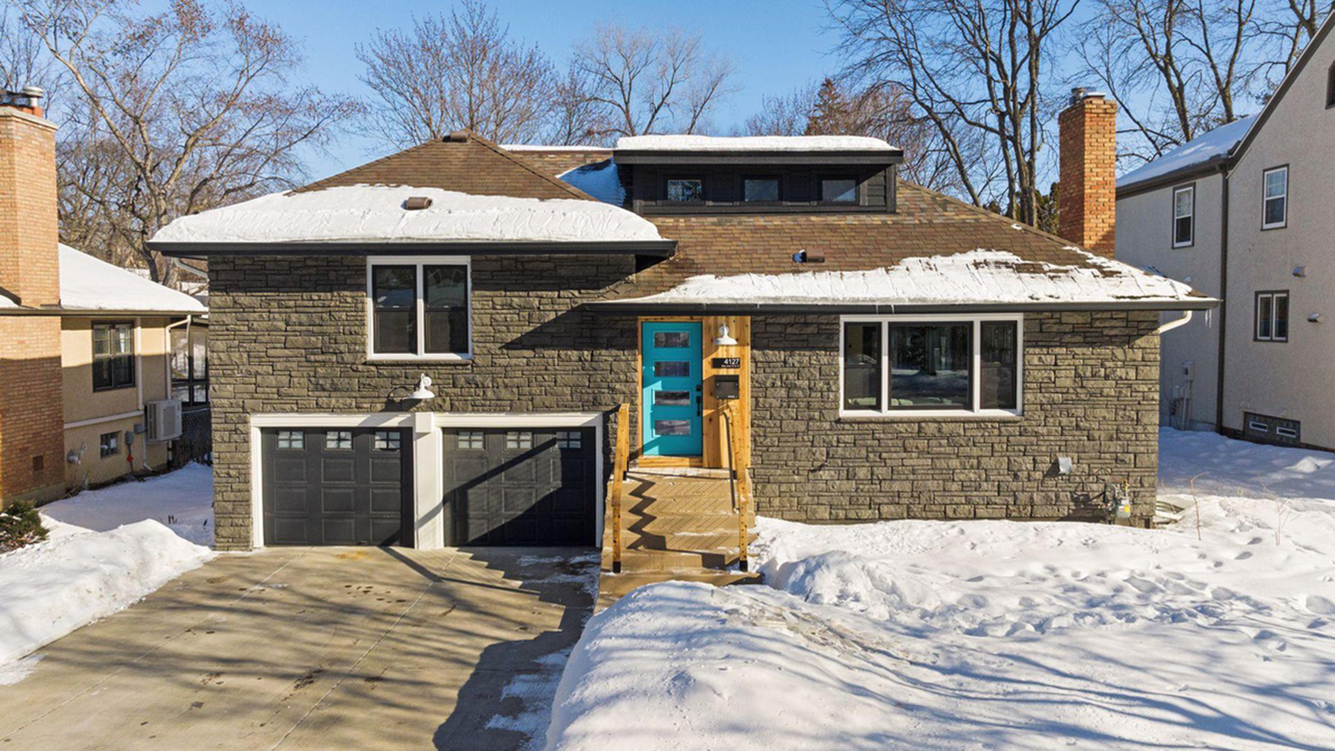 Stone house with electric blue front door and wood trim