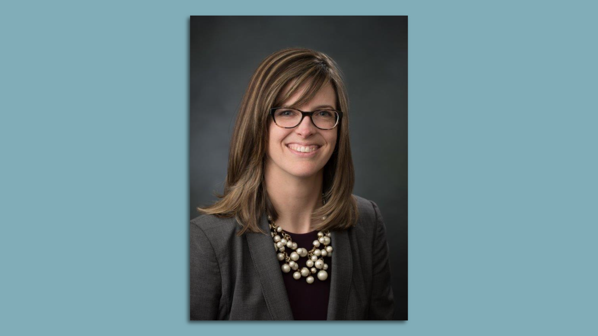 Headshot of a woman wearing glasses and a black shirt