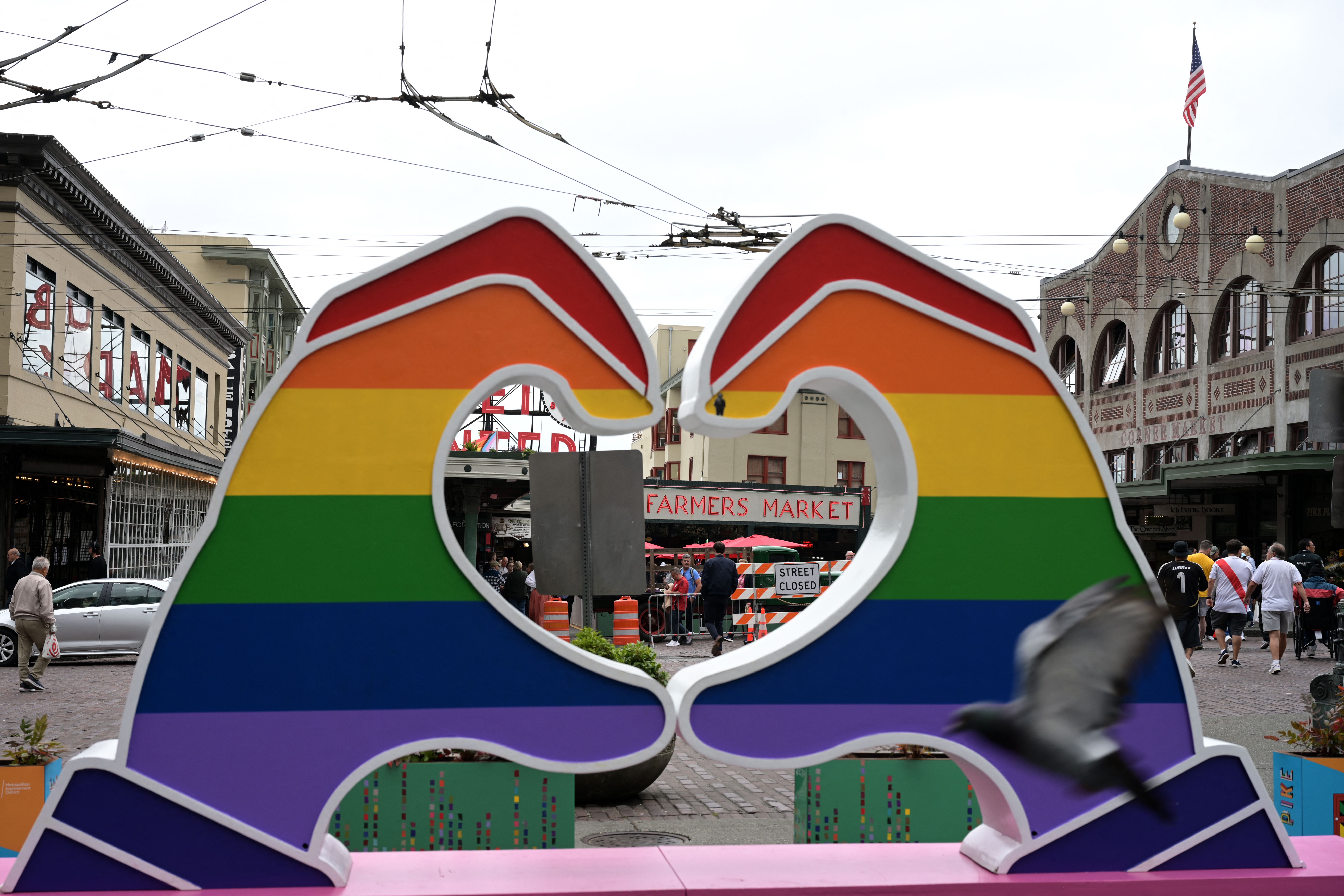 An art installation with large rainbow hands in front of Pike Place Market. 