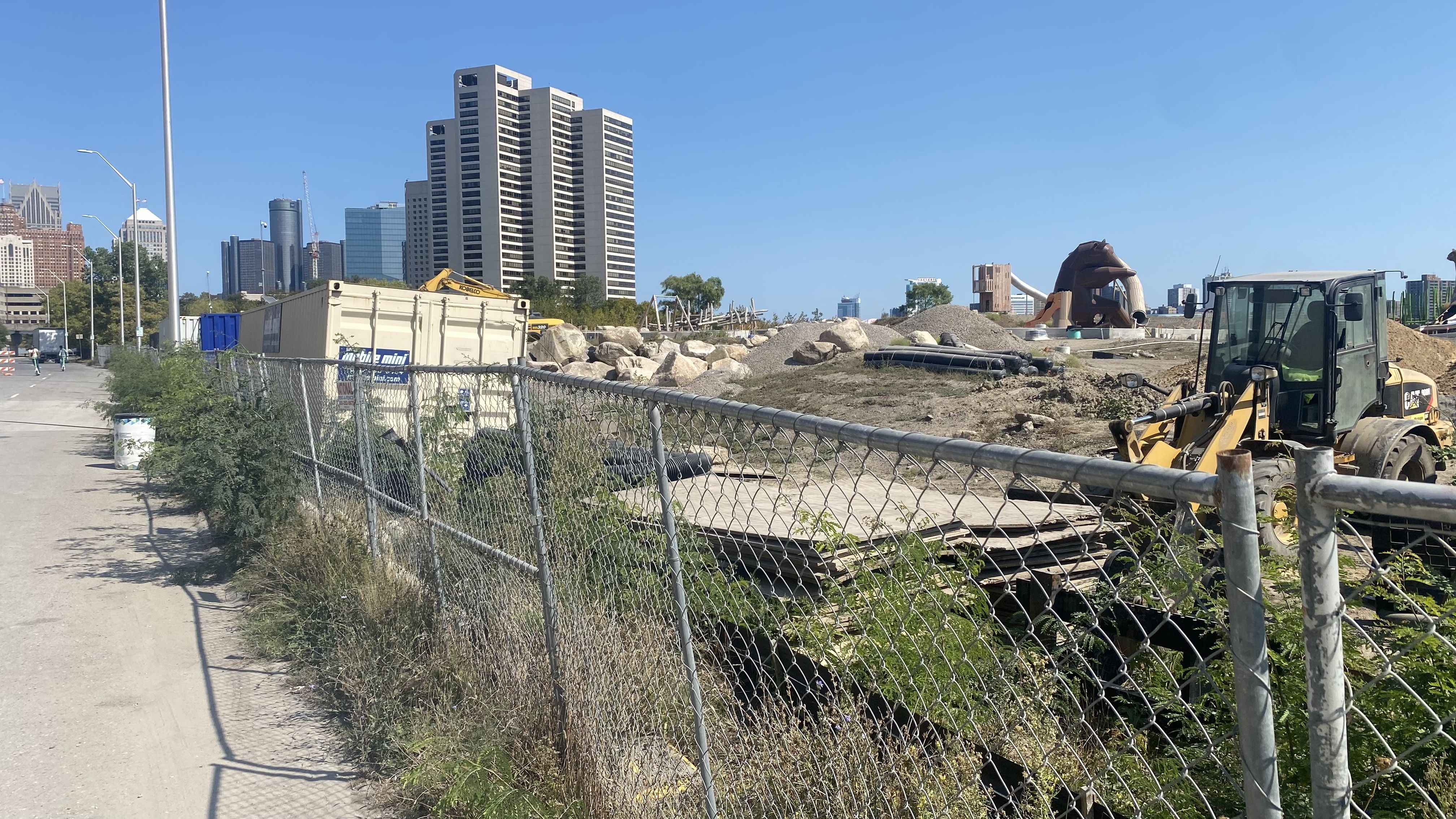 A shot of the construction site with equipment and mounds of dirt.