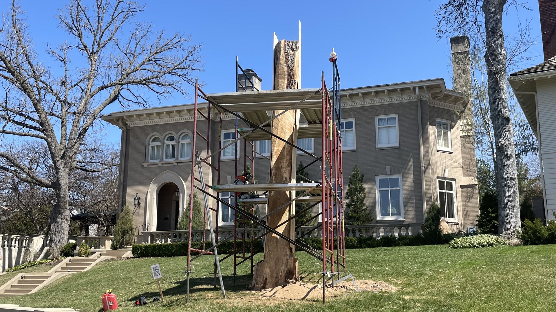 A large house with a tree in front.