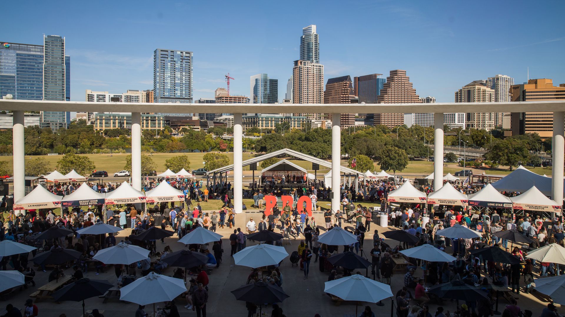 An aerial view of a crowd on the Long Center patio with the Austin skyline in the background.