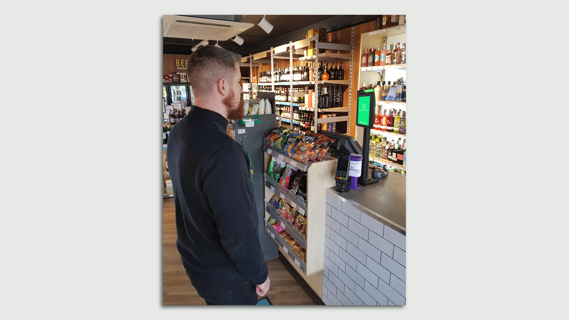 A man faces a screen in a liquor store to verify his age.