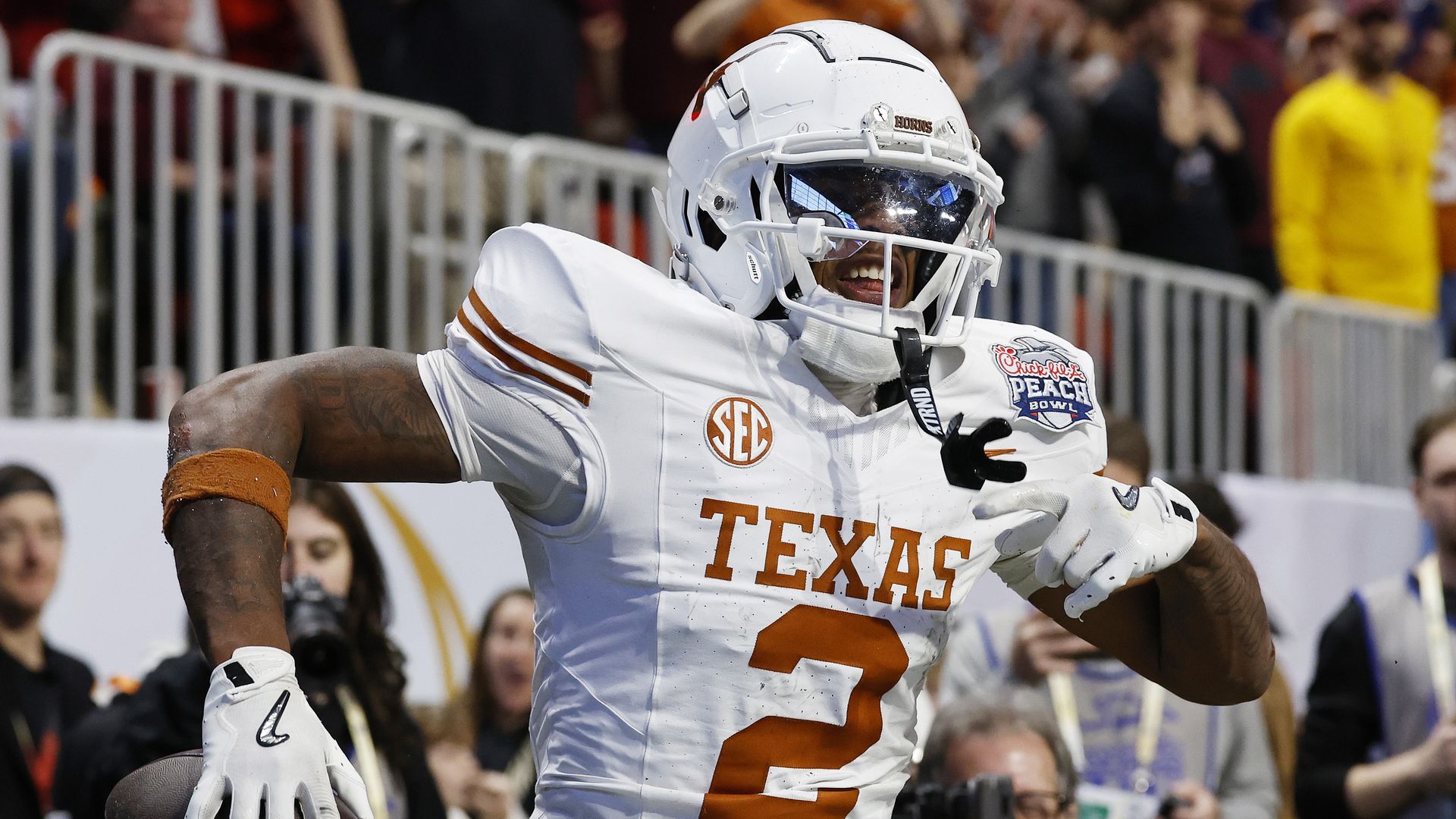 Matthew Golden #2 of the Texas Longhorns  has his arms midair as he celebrates after scoring a 2-point conversion during the second overtime against the Arizona State Sun Devils in the Chick-fil-A Peach Bowl at Mercedes-Benz Stadium. 