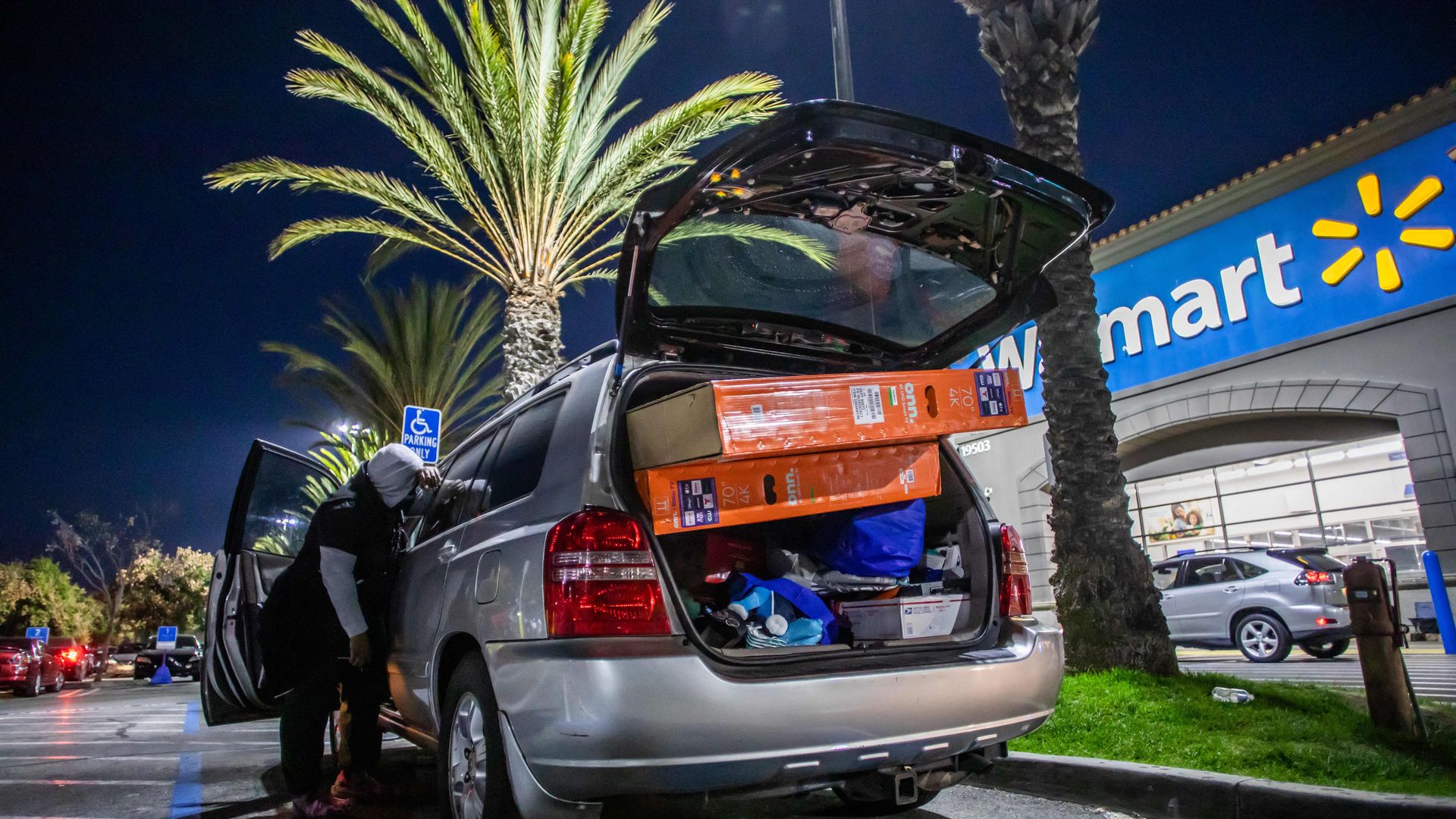   A car trunk in a Walmart parking lot is loaded with two television sets and other items following Black Friday shopping on November 26, 2021 in Torrance, California. 