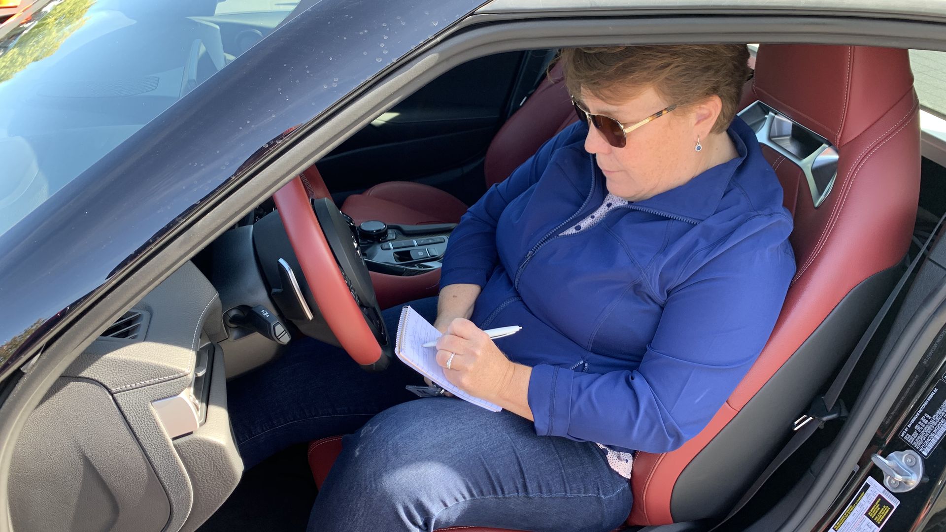 Image of me (Joann Muller) taking notes inside a car