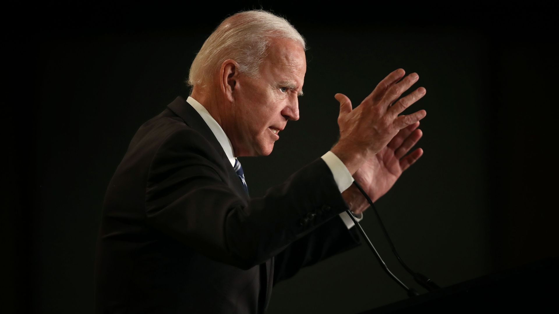 In this image, Biden stands with his hands outstretched. 