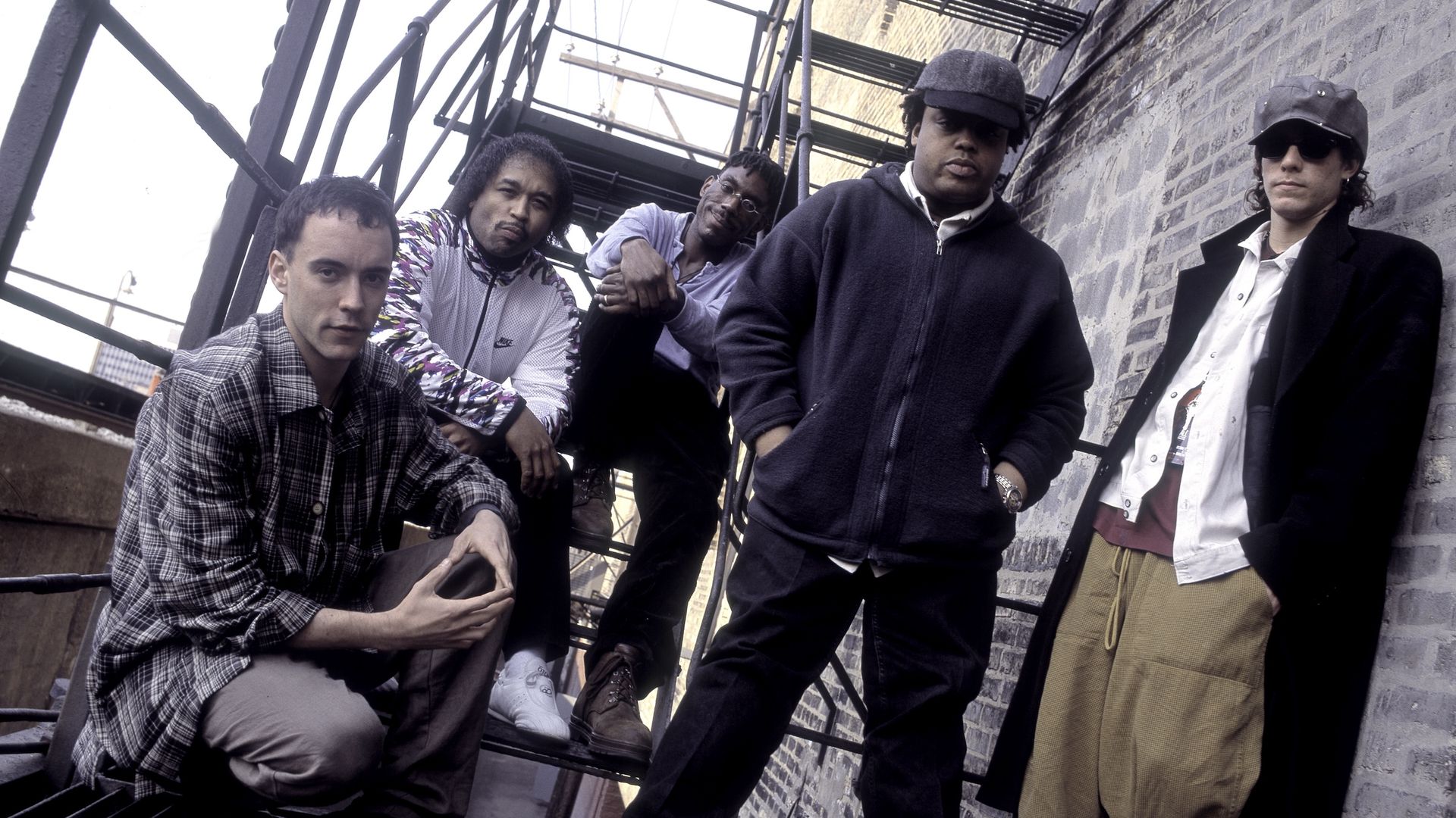 Members of Dave Matthews Band pose for a photo on a fire escape. 